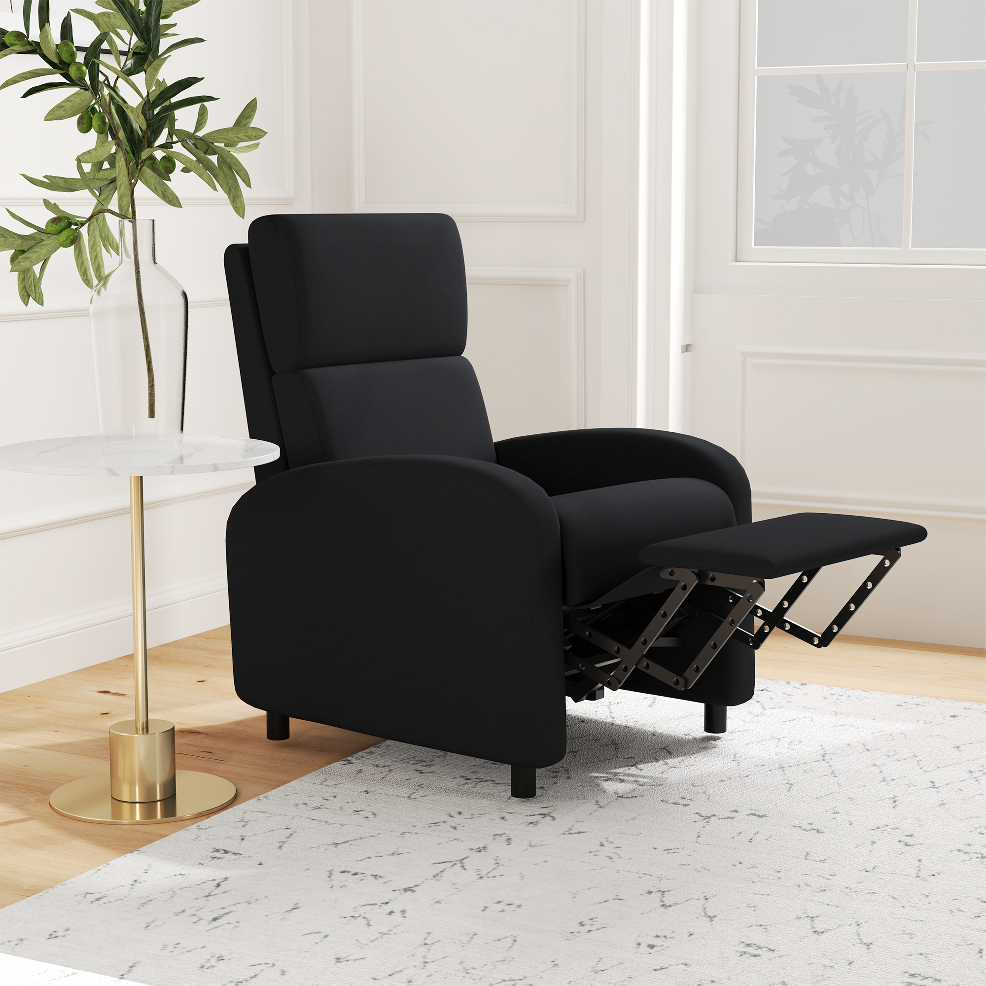 Sillón reclinable negro con reposapiés extendido junto a mesa auxiliar.