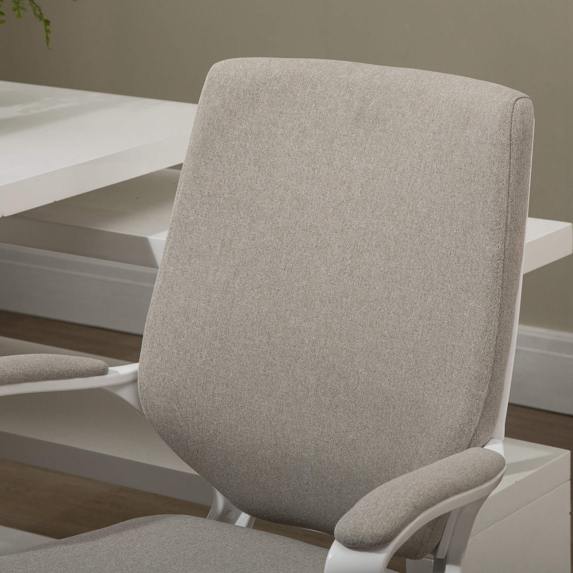 Silla de oficina gris con marco blanco, vista del respaldo y reposabrazos.