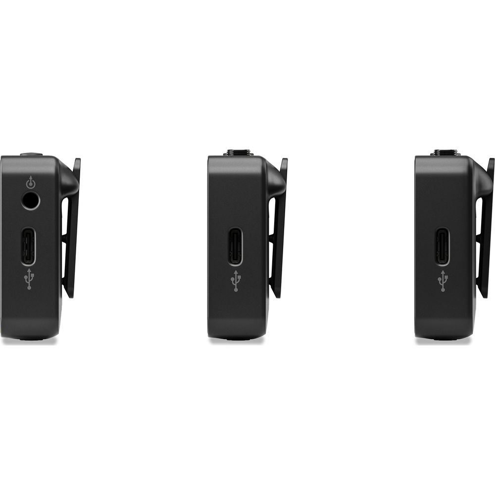 Tre trasmettitori microfonici neri con porte USB e clip.