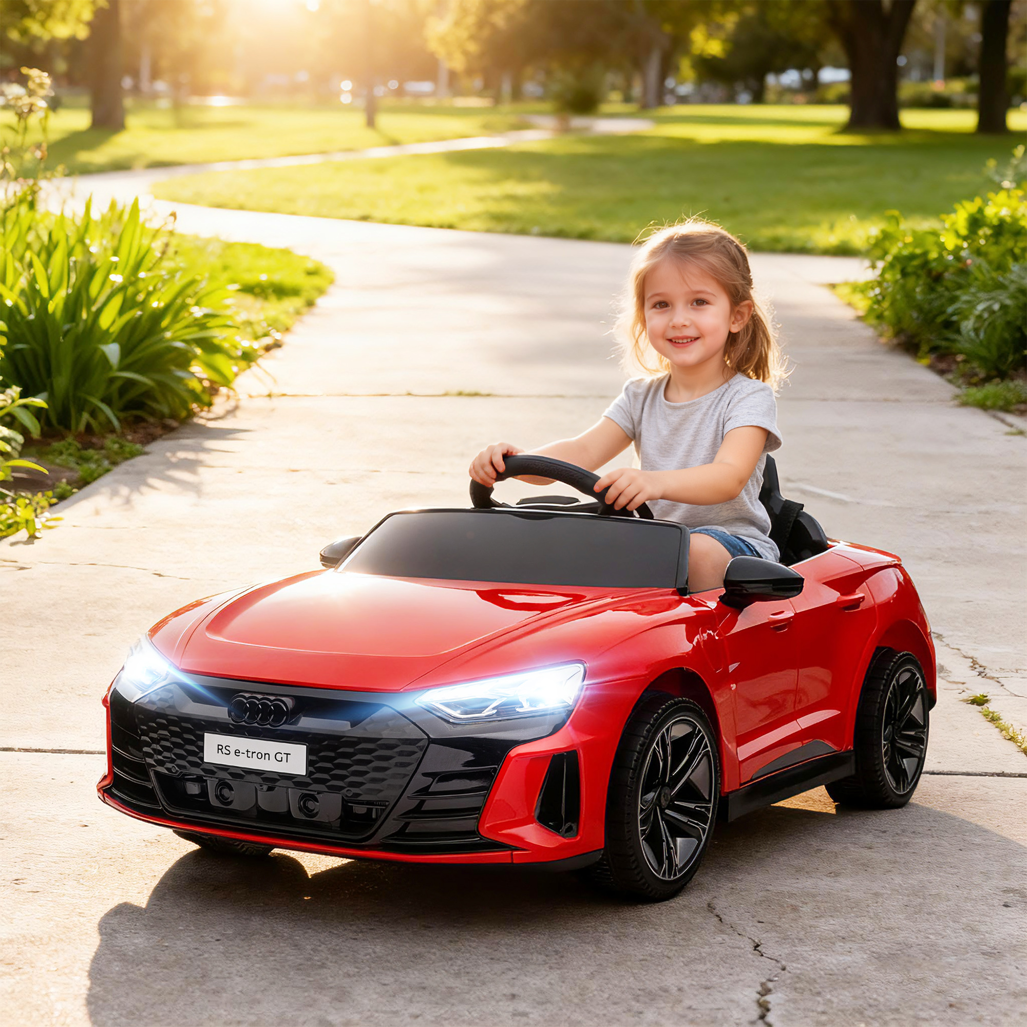 Una niña conduce un coche de juguete rojo por un sendero del parque.