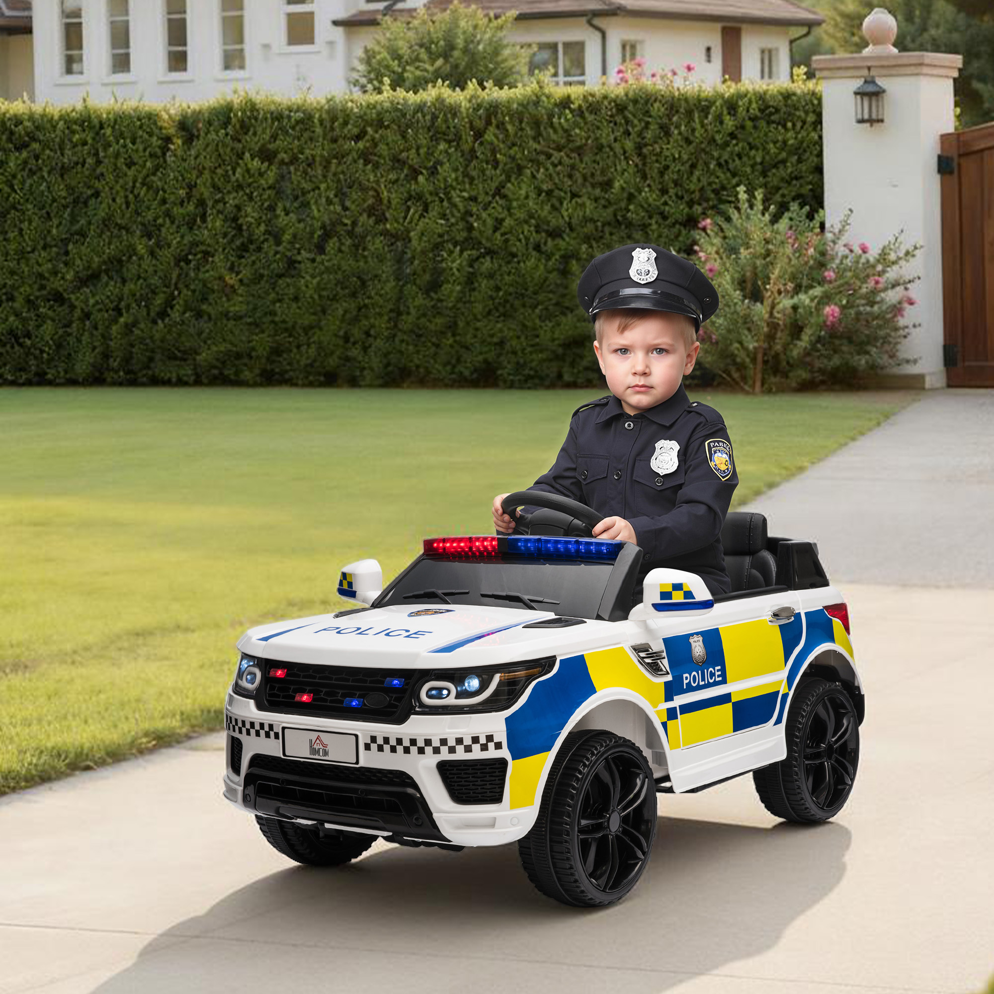 Un niño con uniforme de policía se sienta en un coche de policía blanco con rayas azules y amarillas.