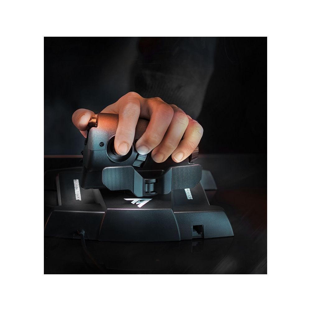 Ręka obsługuje czarny joystick z dźwigniami gazu na ciemnym tle.