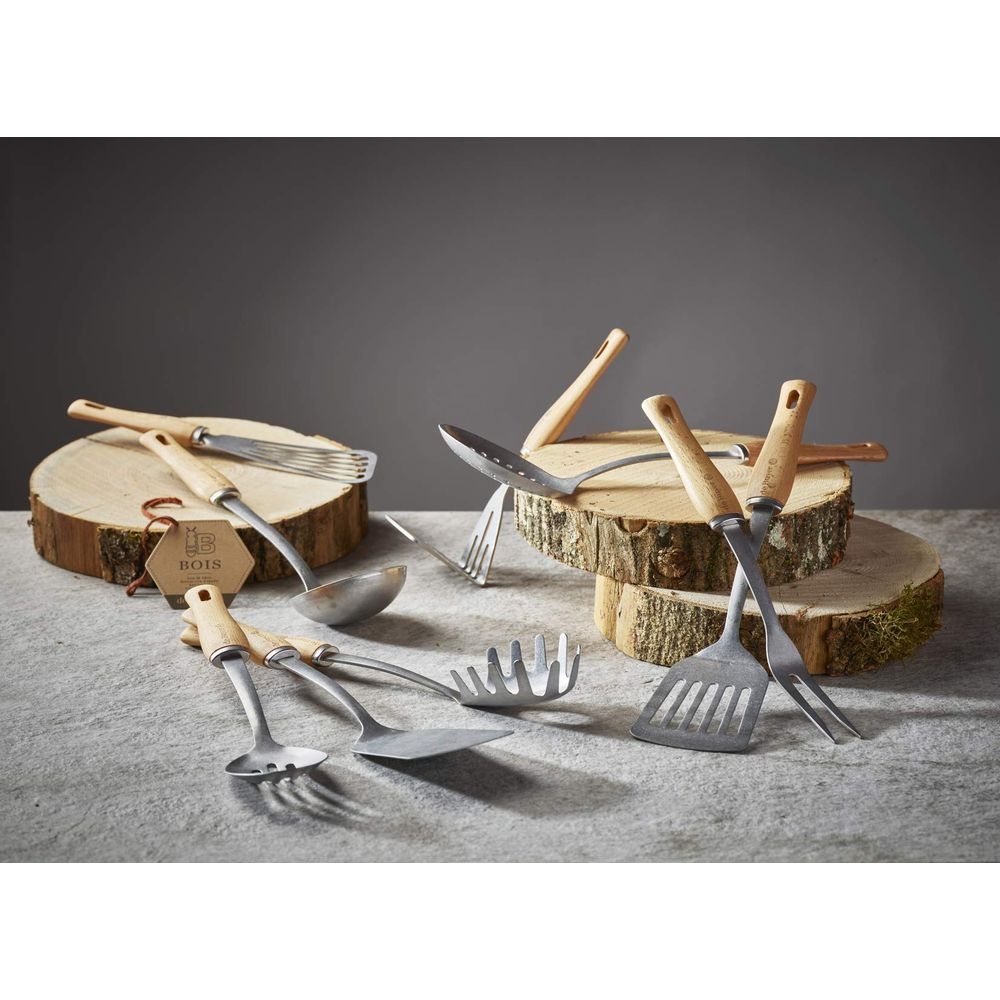 Set aus Küchenutensilien aus Edelstahl mit Holzgriffen auf rustikalen Holzscheiben.
