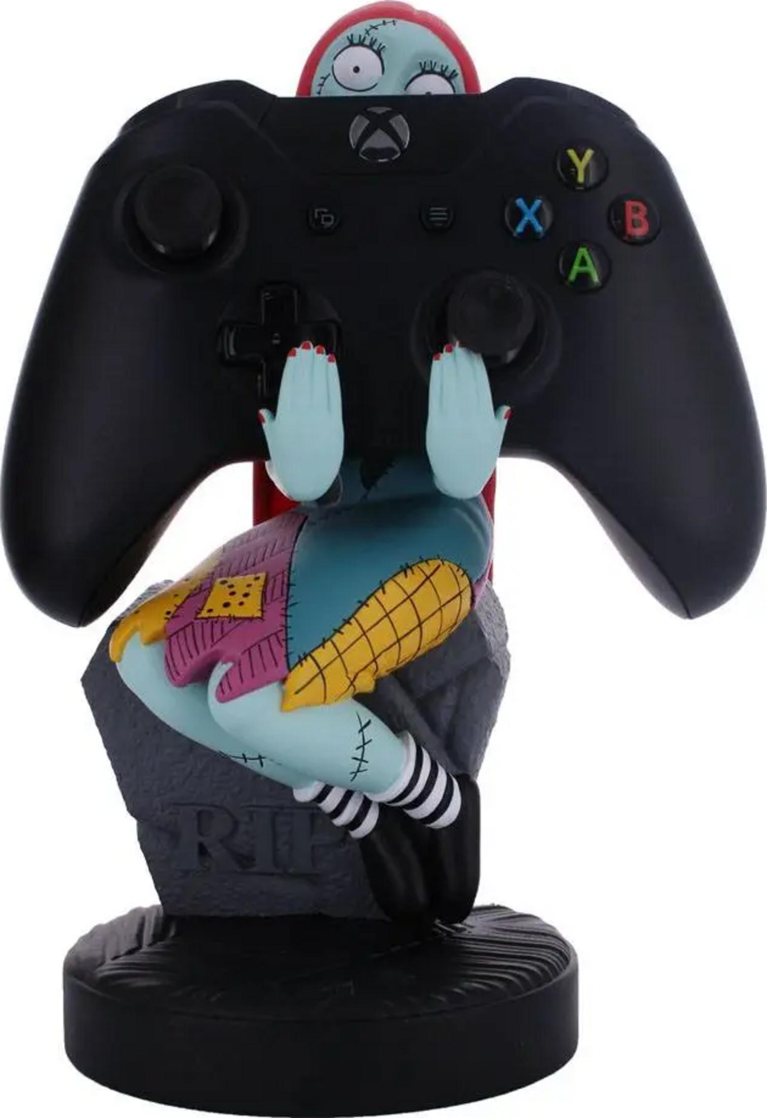 Figurka Sally trzymająca czarny kontroler Xbox na cokole z nagrobka.