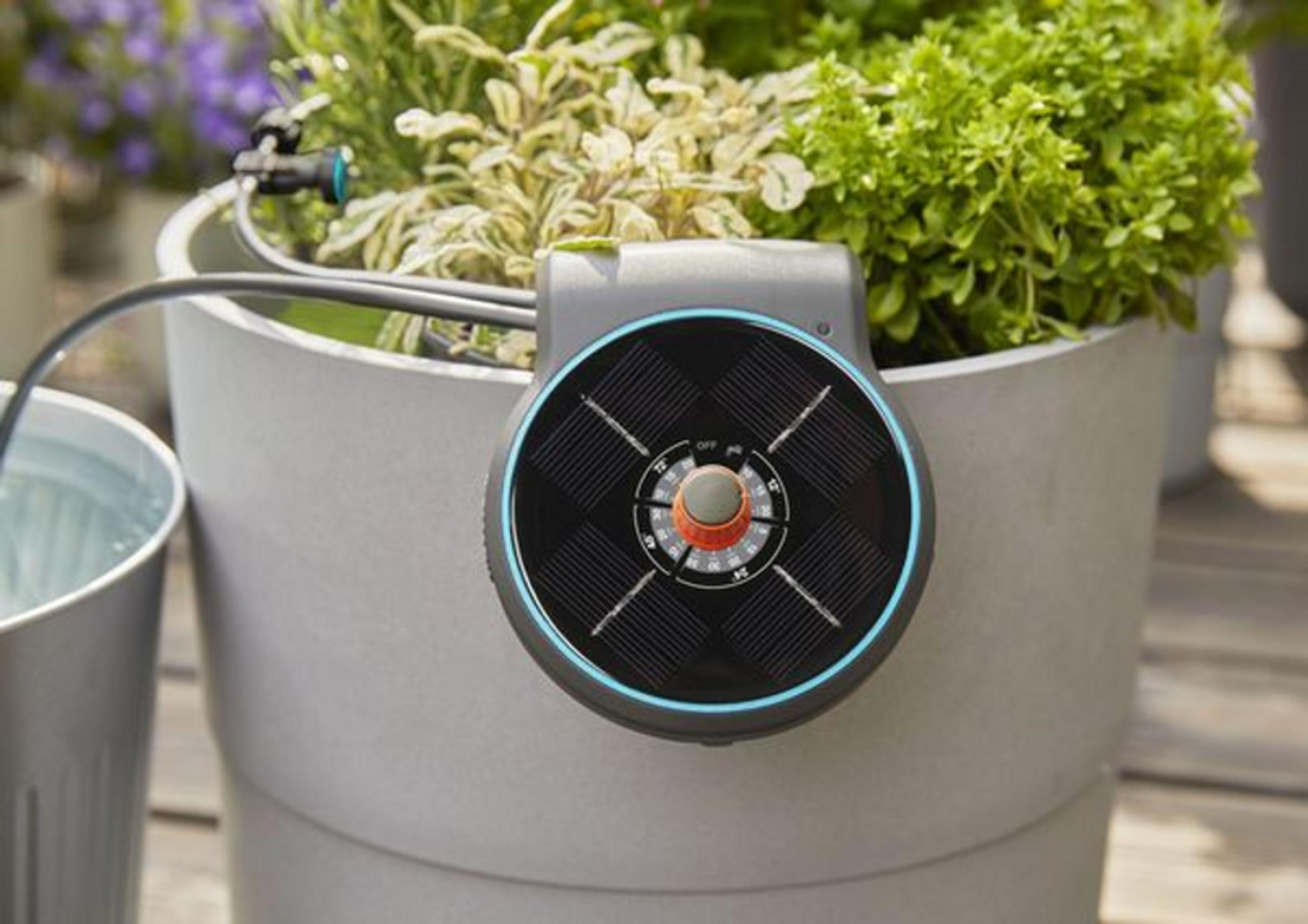 Un dispositivo de riego solar en una maceta con plantas.
