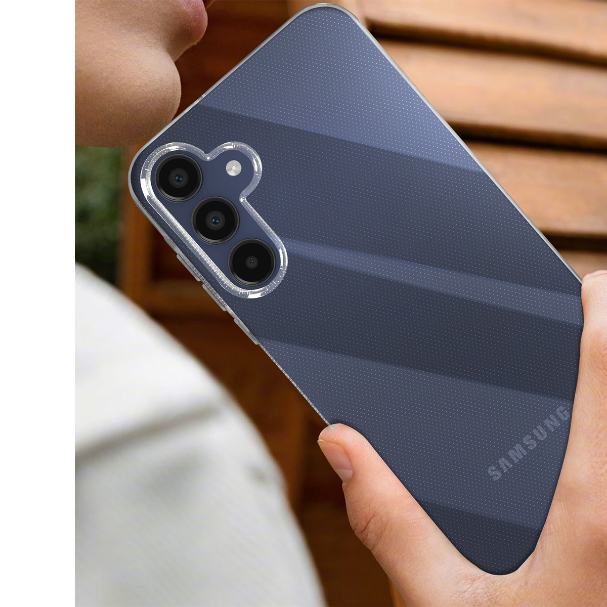Eine Hand hält ein dunkles Samsung Handy mit drei Kameras.