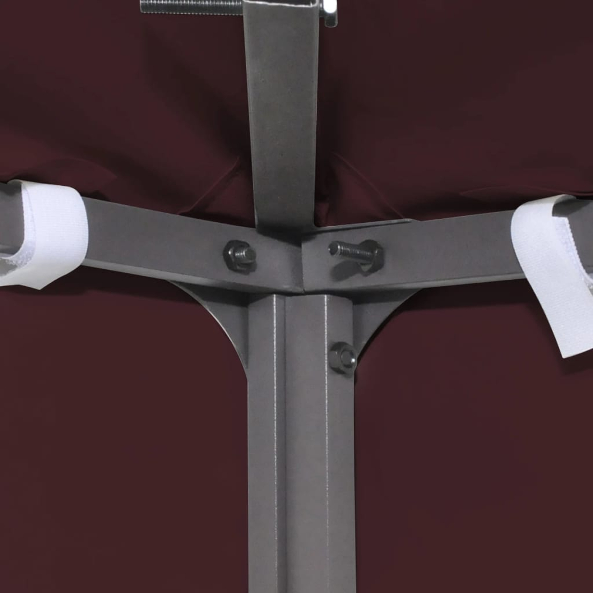 Telaio metallico con bulloni e cinghie in velcro su sfondo di tessuto marrone.