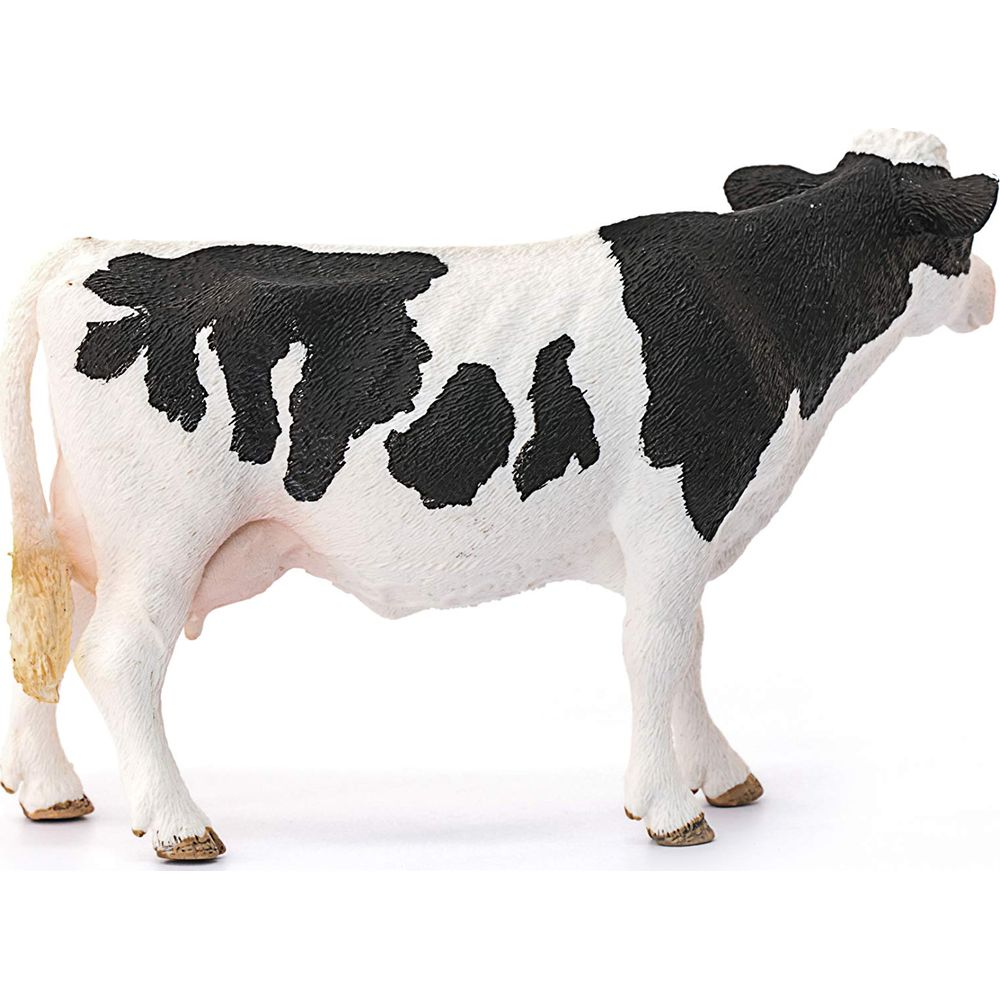 Una mucca maculata bianco e nero sta su sfondo bianco.