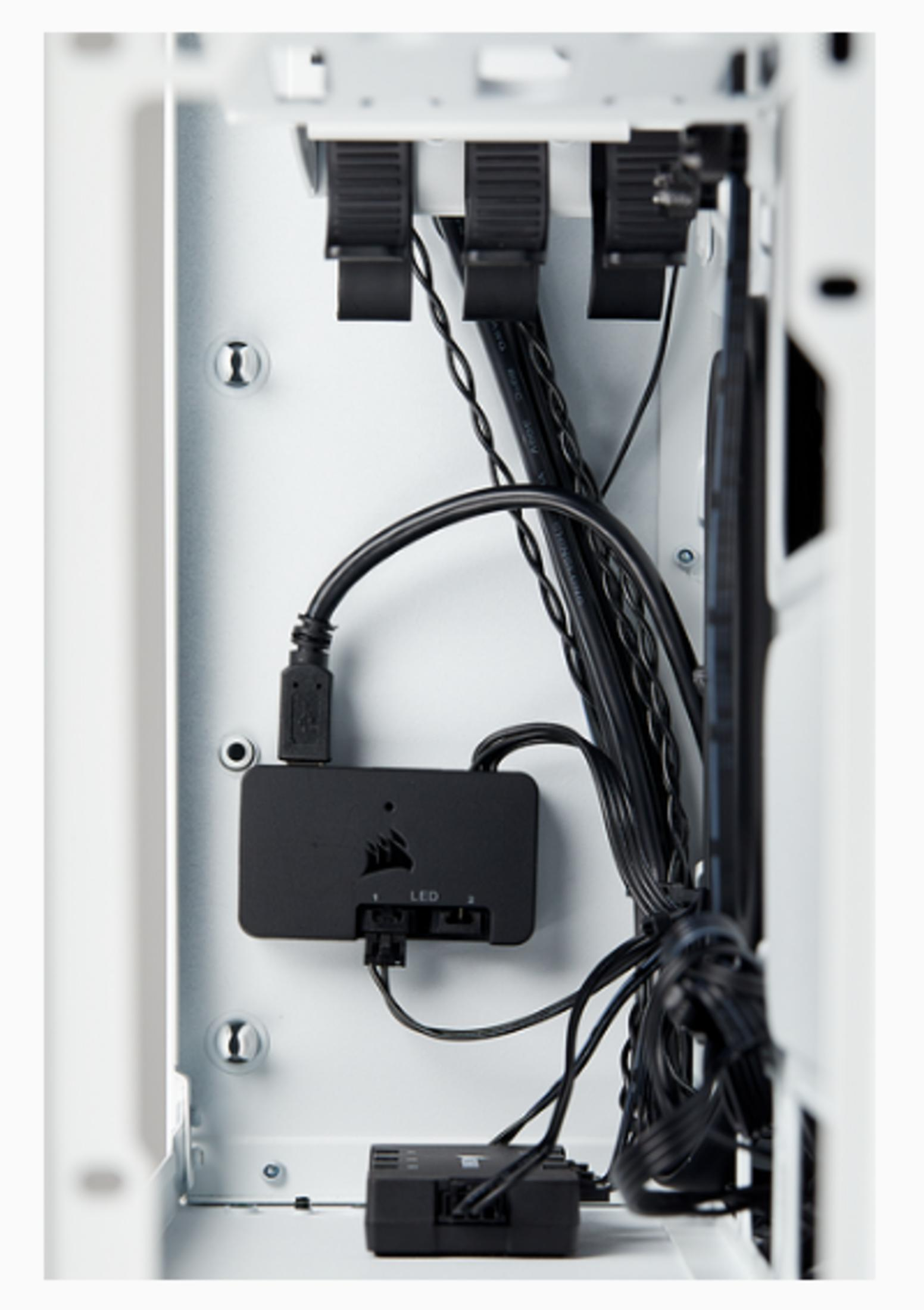 Czarne kable i skrzynki sterujące w białej obudowie komputera.