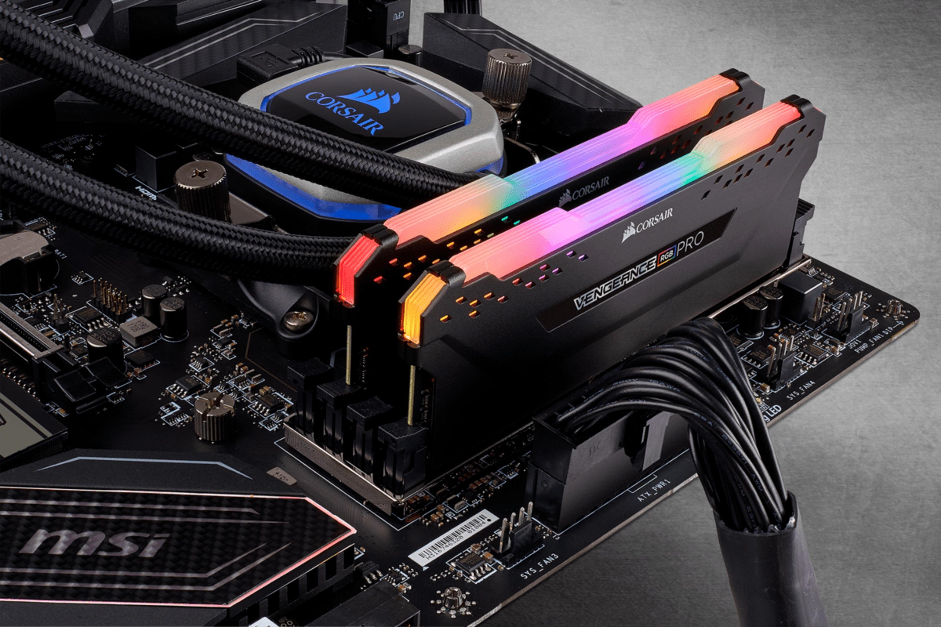 Nahaufnahme eines Computer-Motherboards mit RGB-RAM-Riegeln und einem Corsair-CPU-Kühler.
