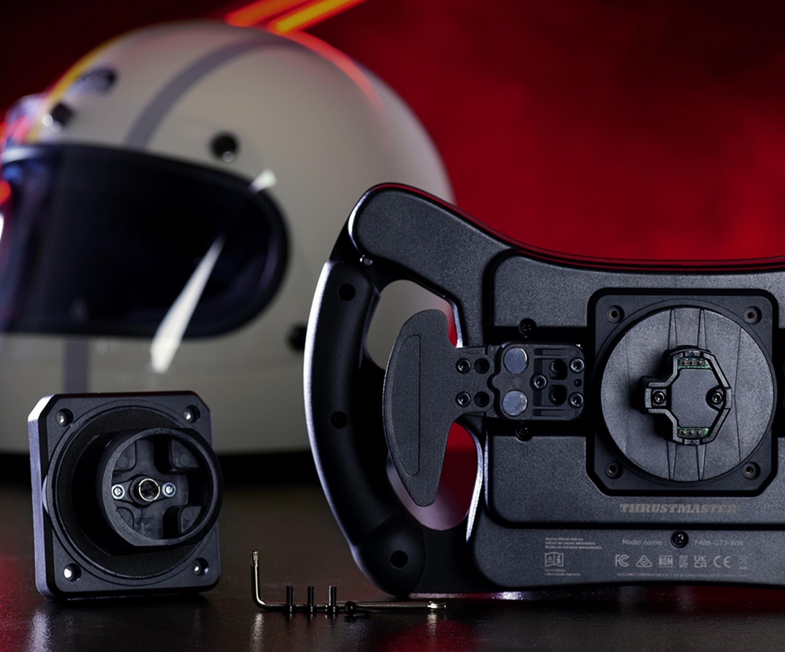 Biały kask i czarna kierownica wyścigowa z akcesoriami na ciemnej powierzchni.