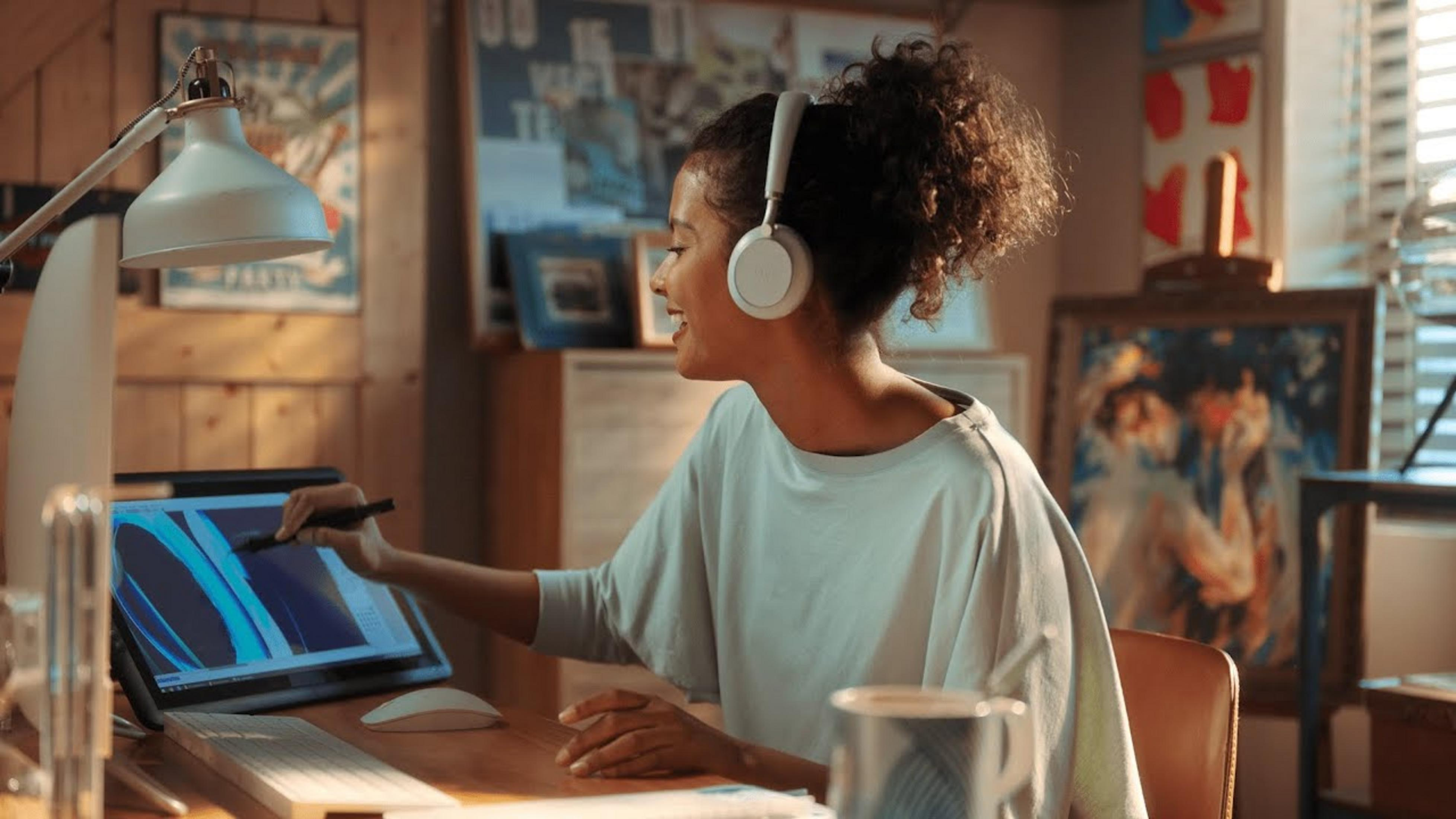 Una donna con cuffie disegna su un tablet.