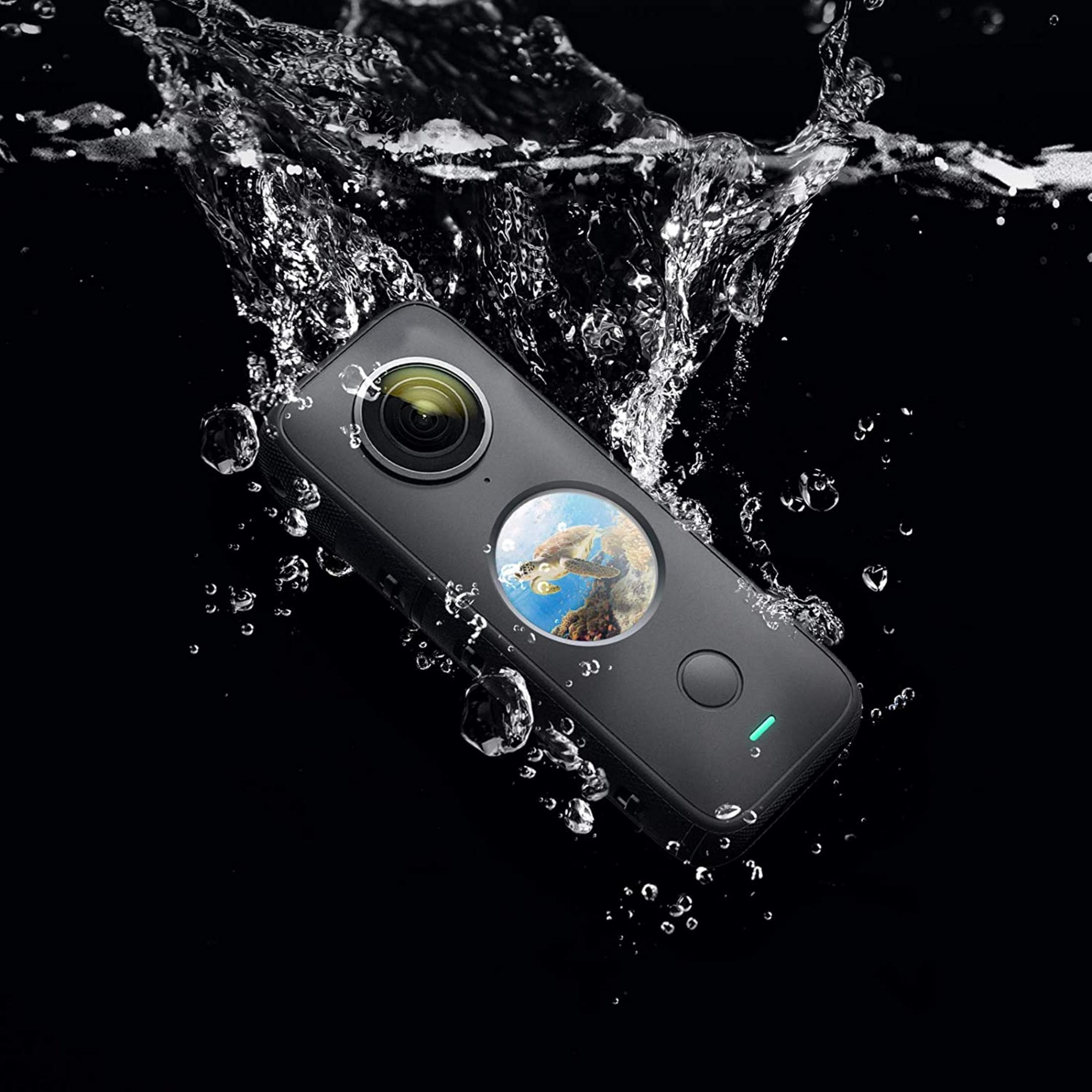 Eine schwarze Kamera taucht in Wasser, mit Wasserstrahlen und Blasen.