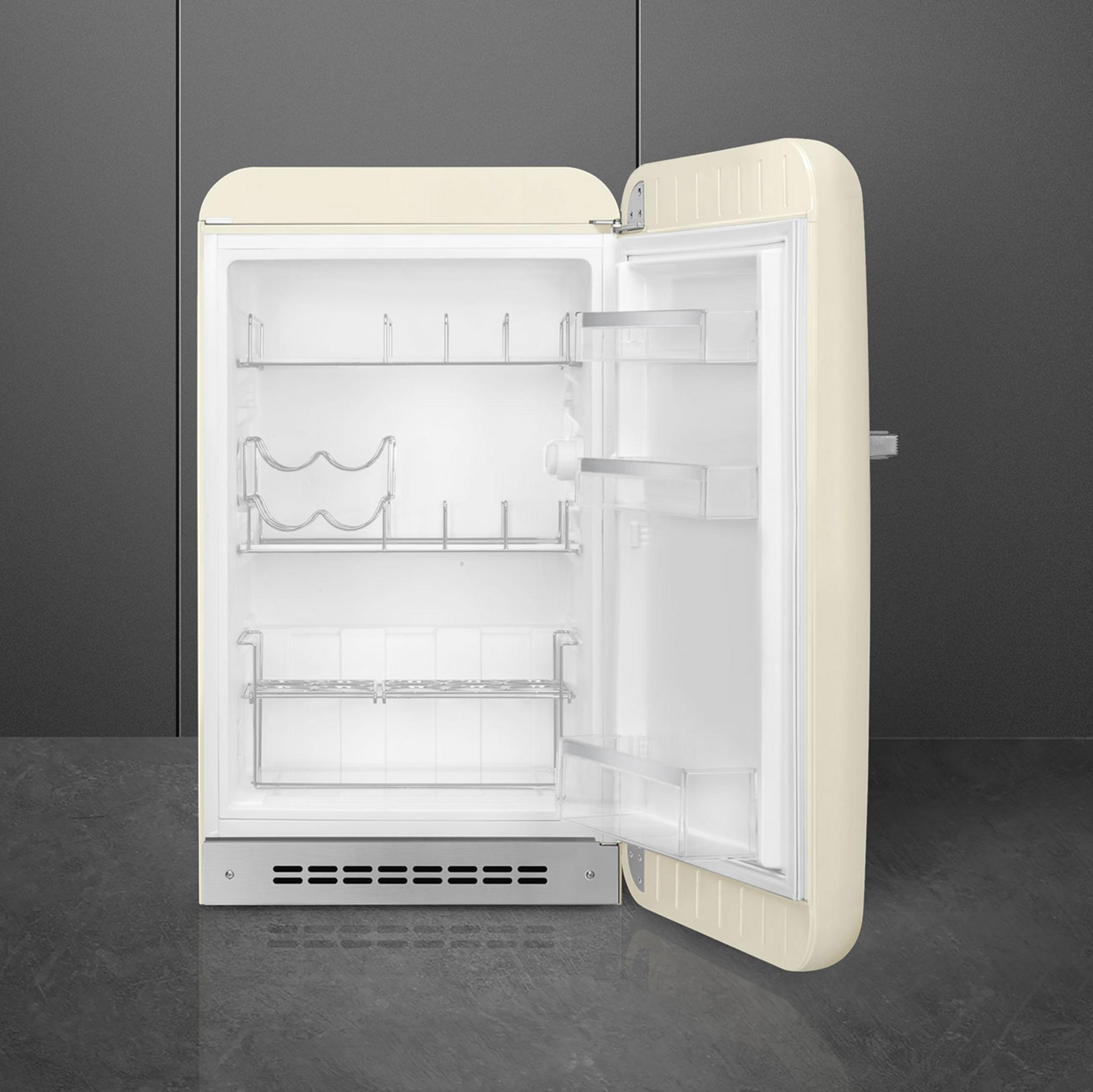 Un refrigerador abierto de color crema con estantes y un botellero.