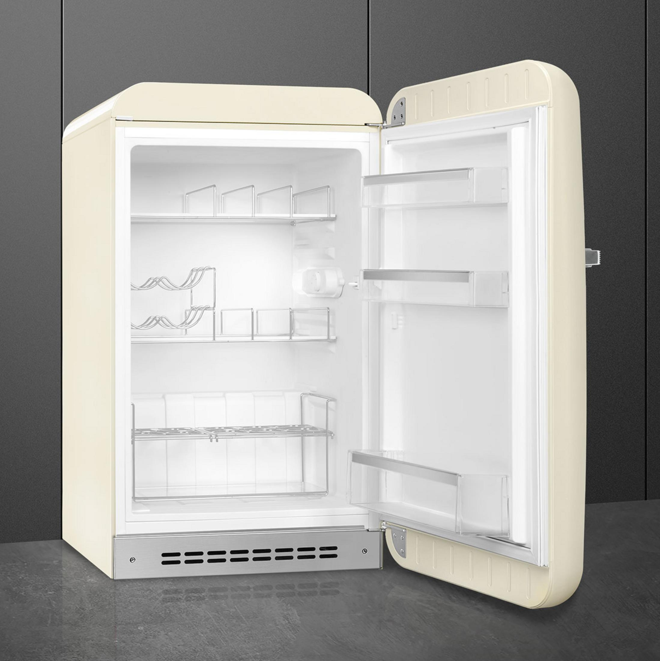 Un refrigerador abierto de color crema con estantes y botelleros.