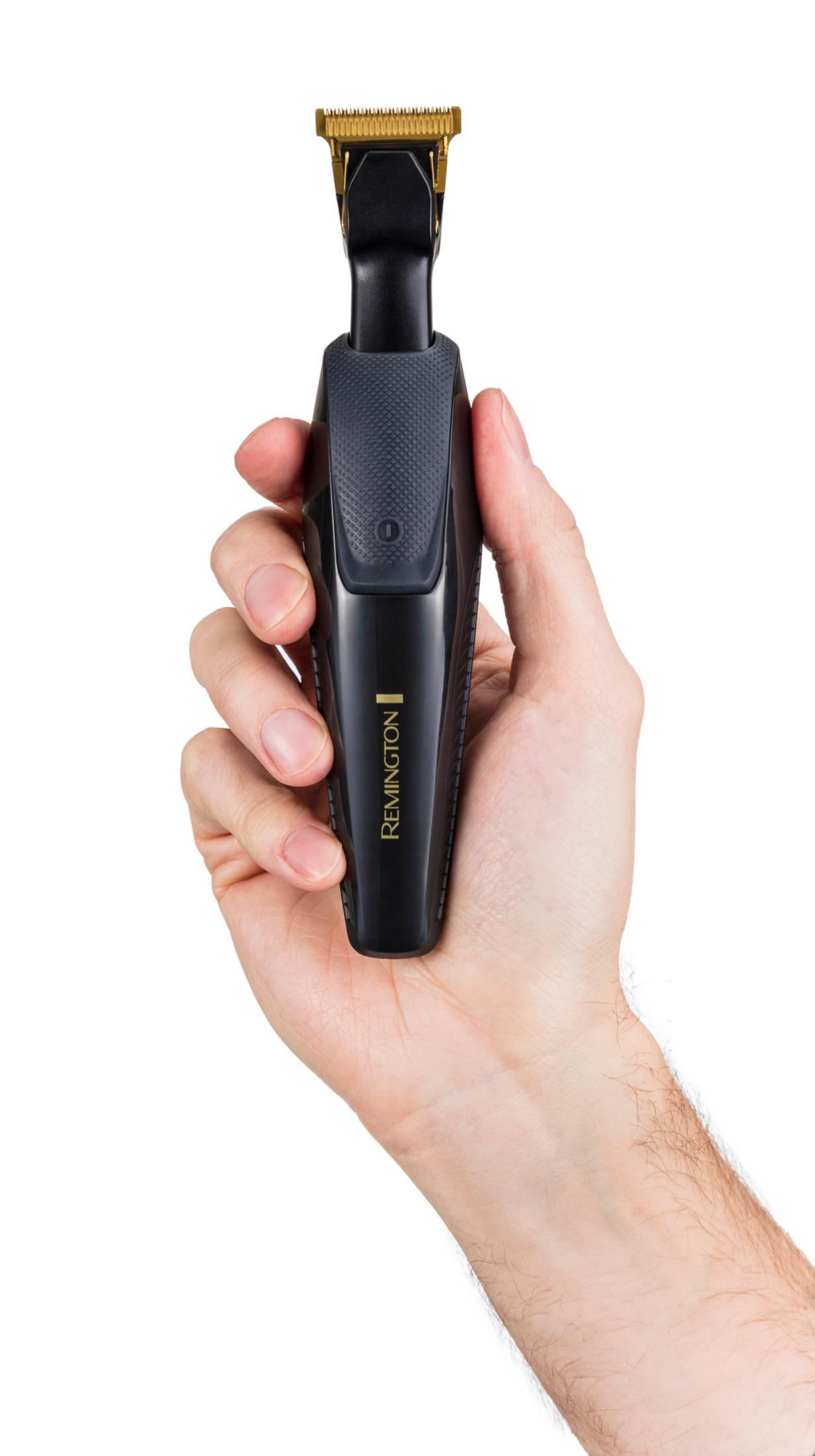 Dłoń trzyma czarną maszynkę Remington ze złotymi ostrzami.
