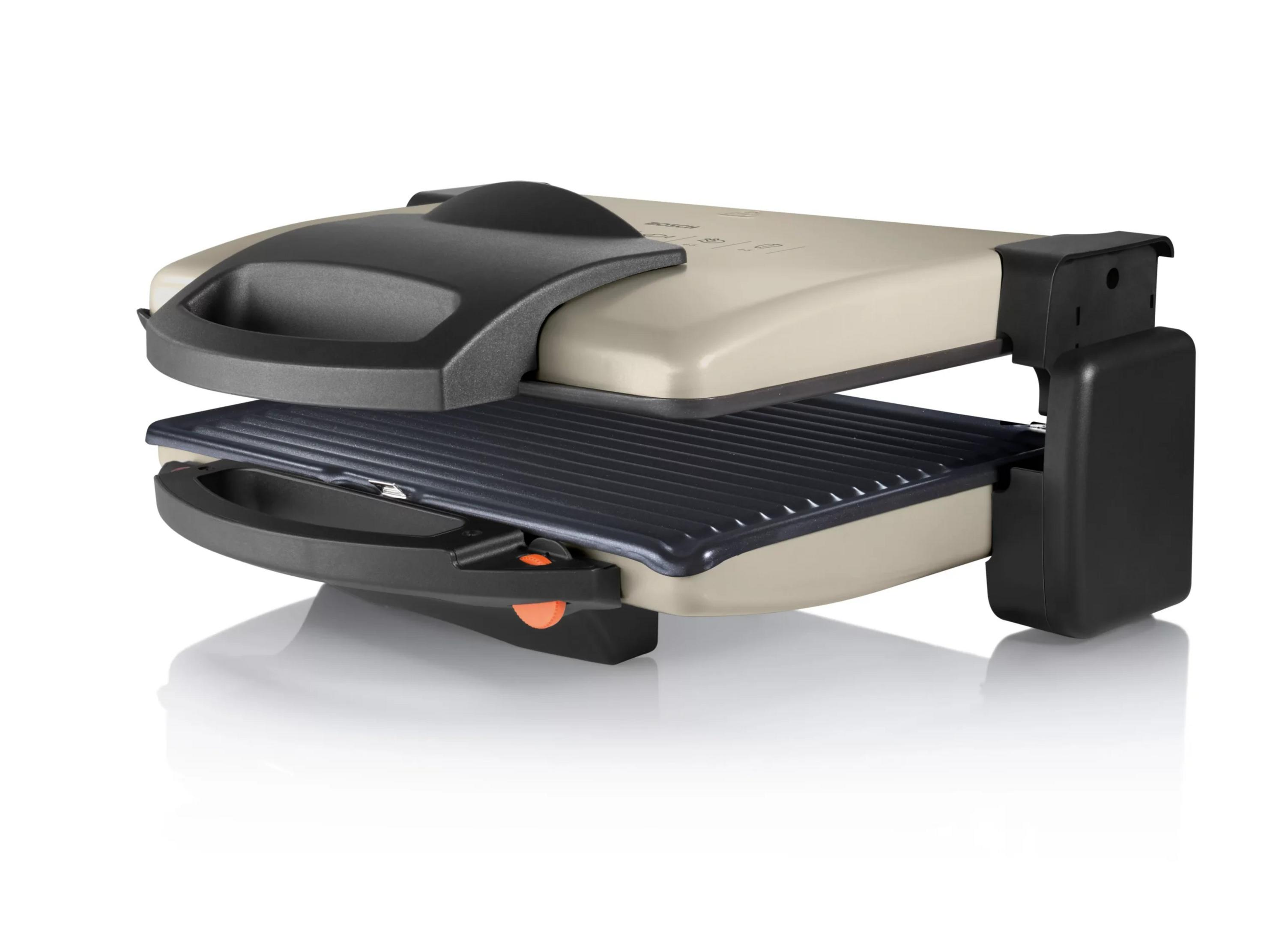 Un tostapane aperto con parte superiore beige e piastra grill nera.
