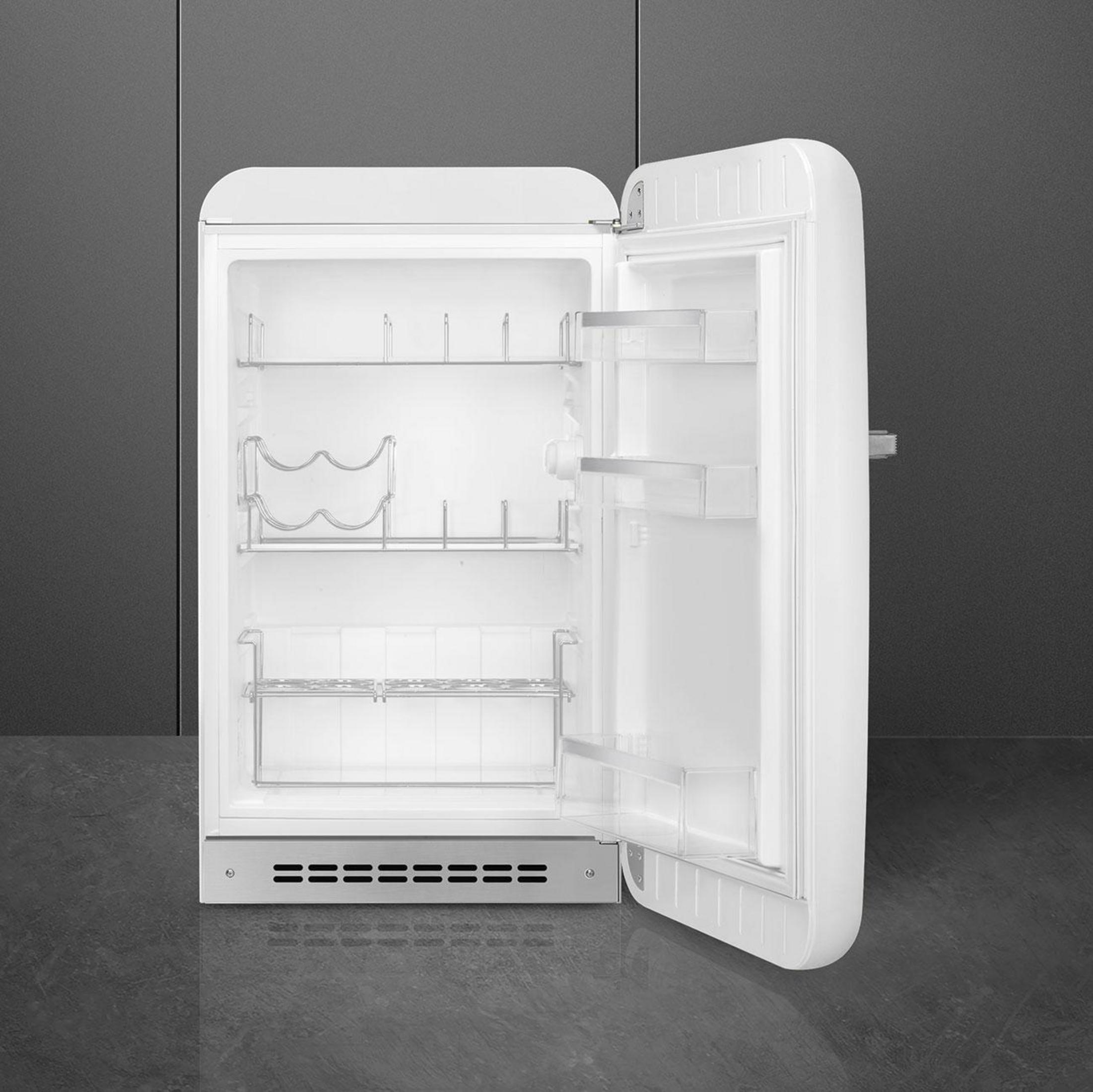 Un refrigerador blanco con la puerta abierta, vacío por dentro con estantes.