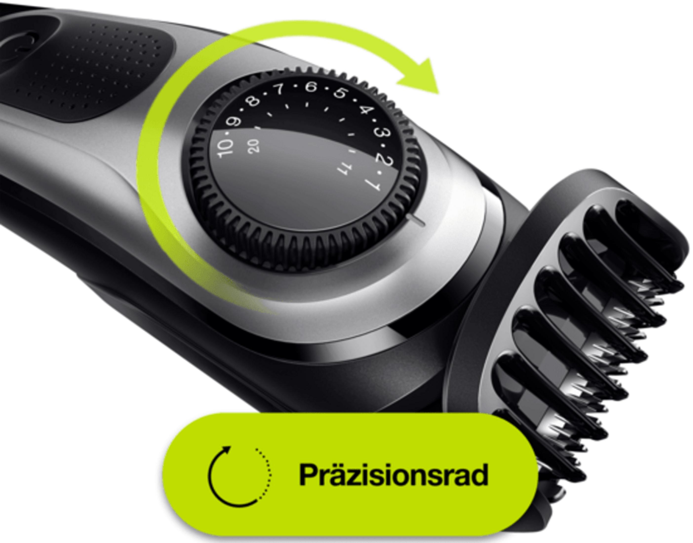 Close-up of a trimmer with an adjustment dial and a green arrow.