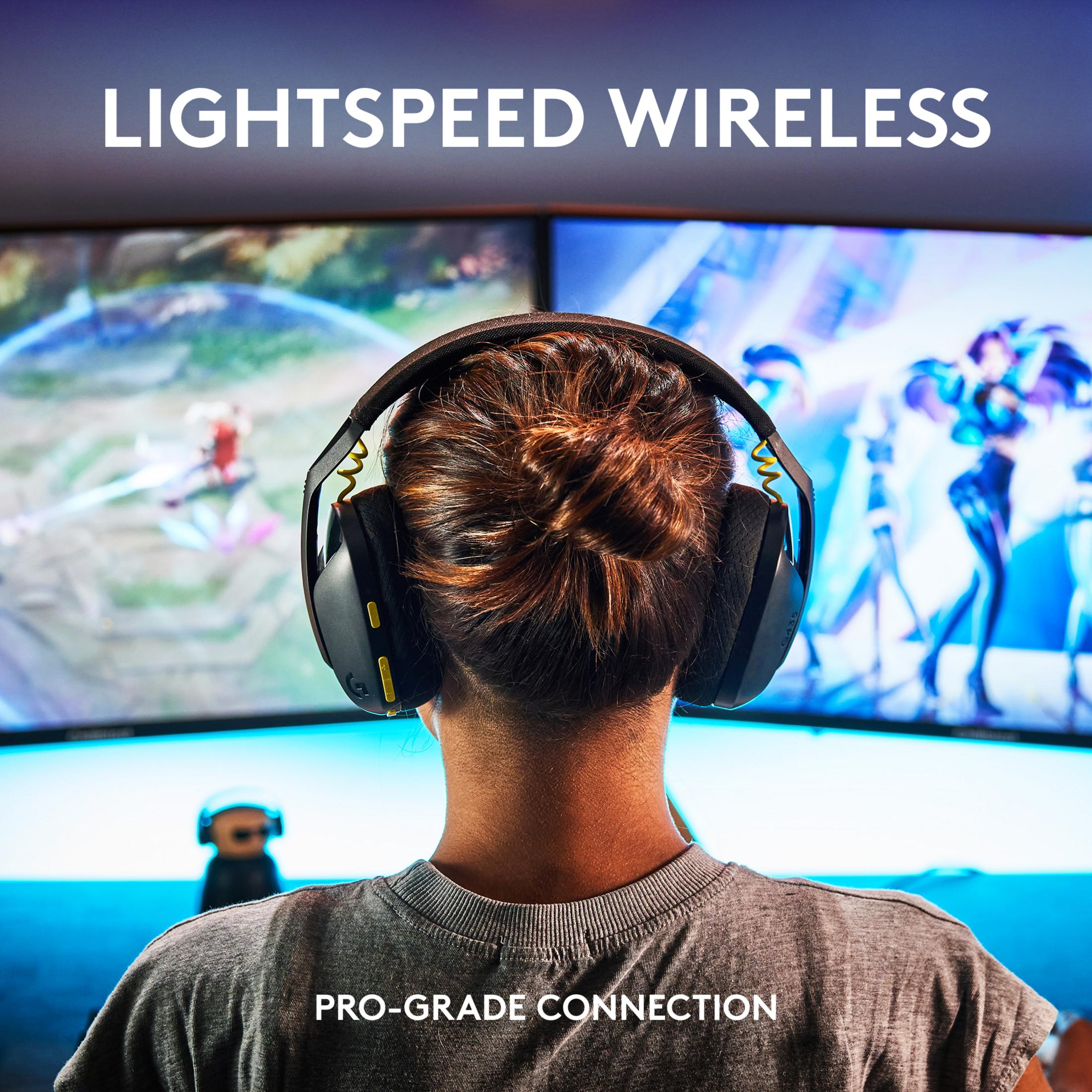 Back view of a person wearing headphones, looking at two screens.
