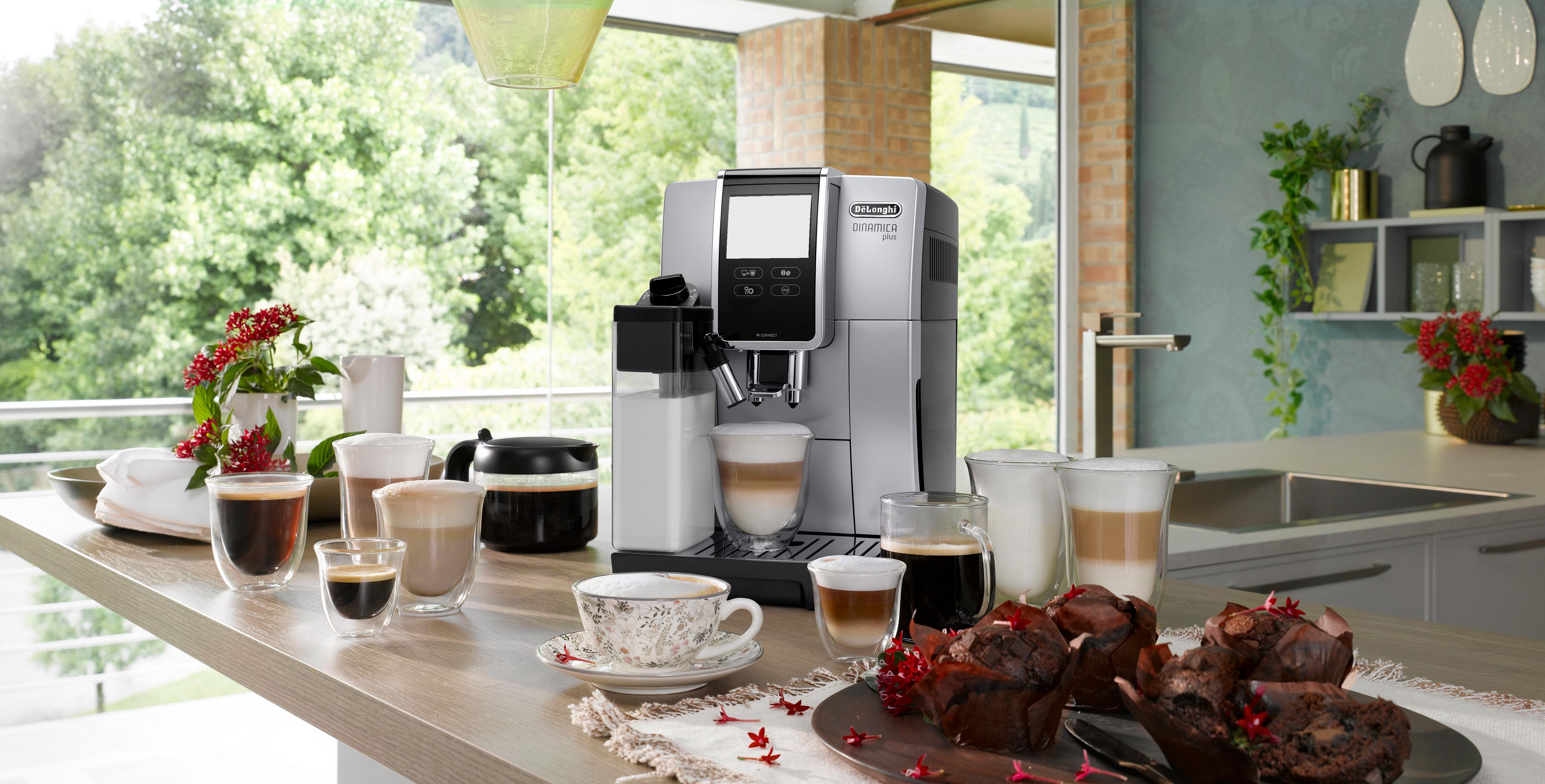 Ekspres do kawy z różnymi kawami i muffinkami na drewnianym blacie.