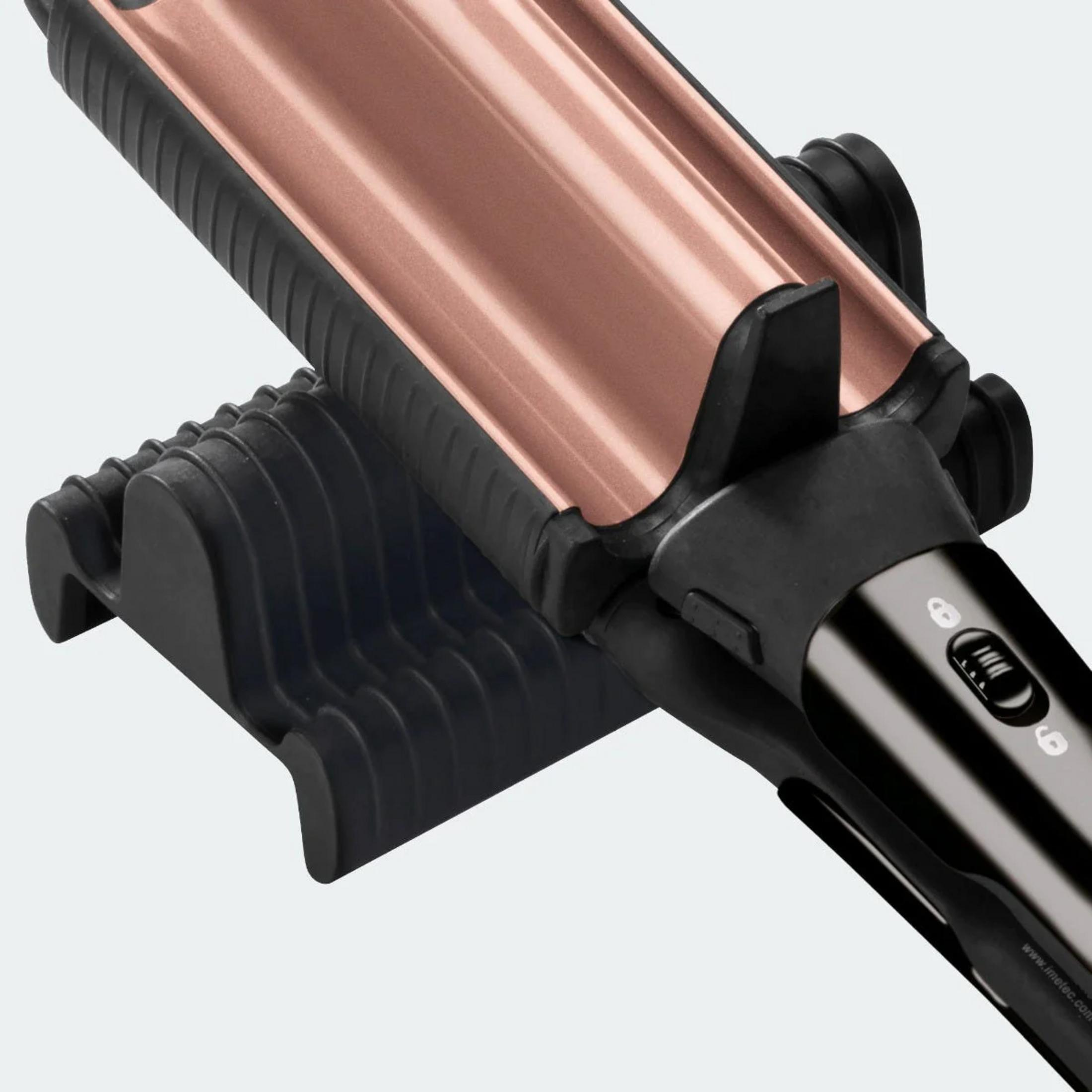 Różowozłota karbownica spoczywa na czarnej podstawie z czarnymi detalami uchwytu.