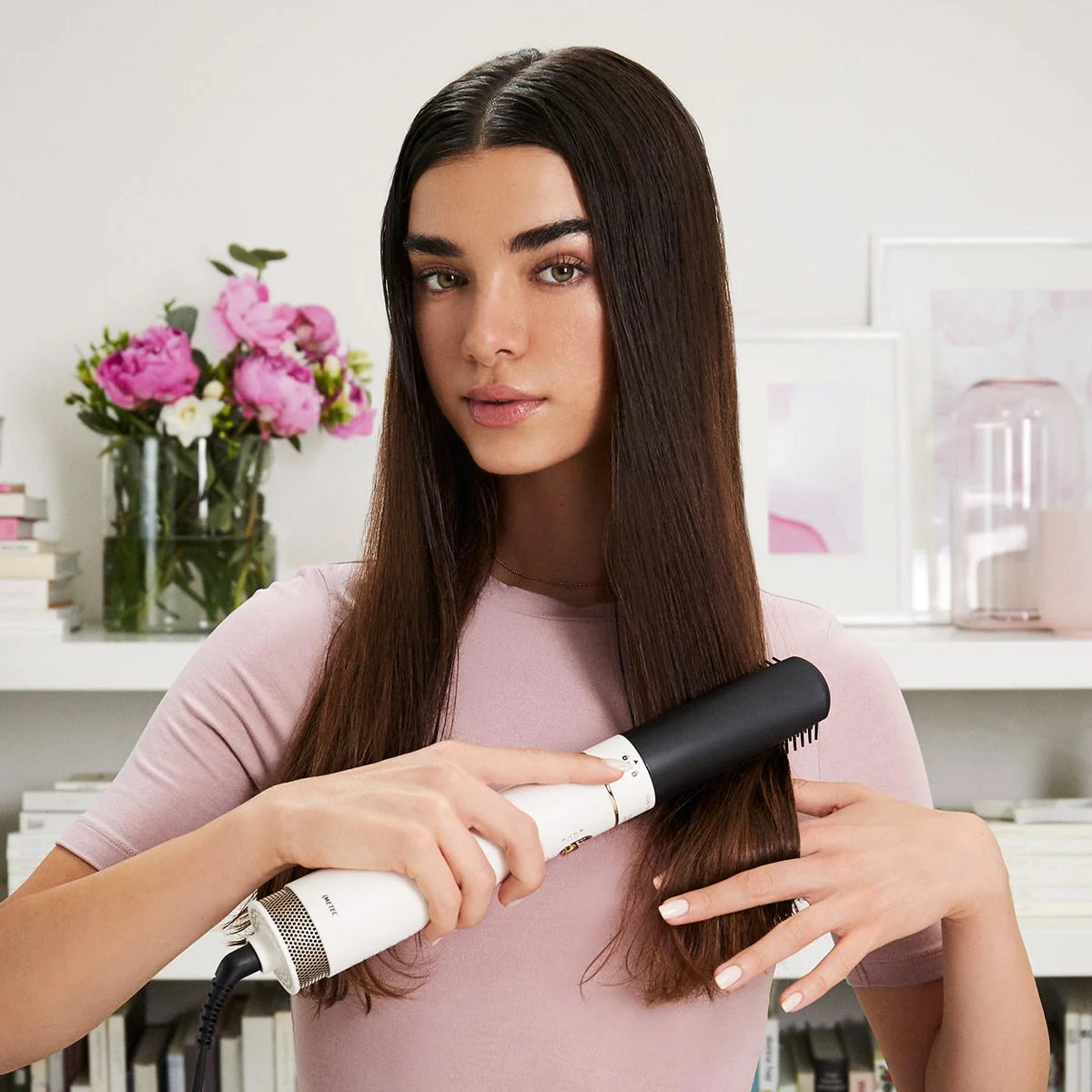 Kobieta z długimi brązowymi włosami używa białej i czarnej stylizacji.