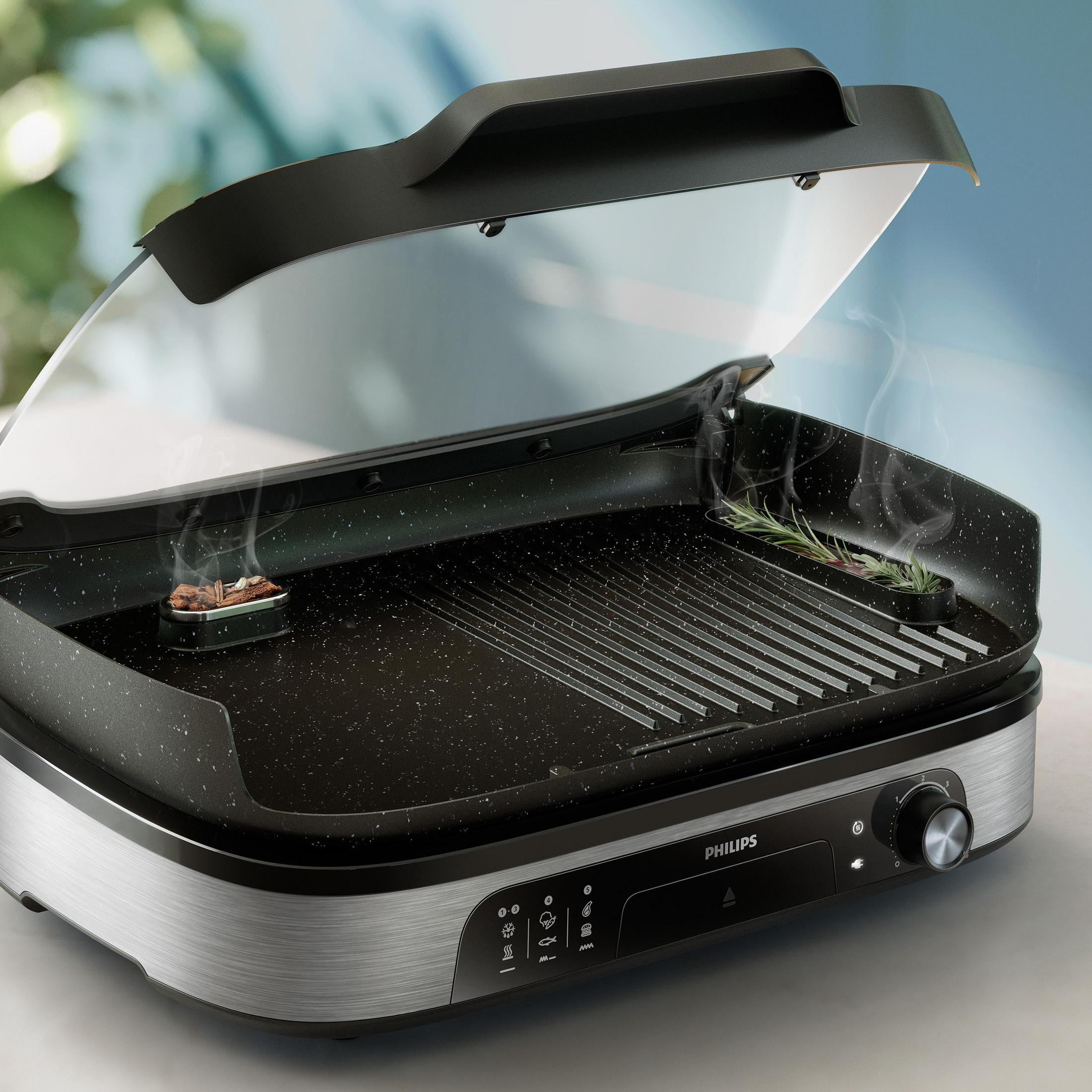 Grill elektryczny z otwartą pokrywą, unoszący się dym.