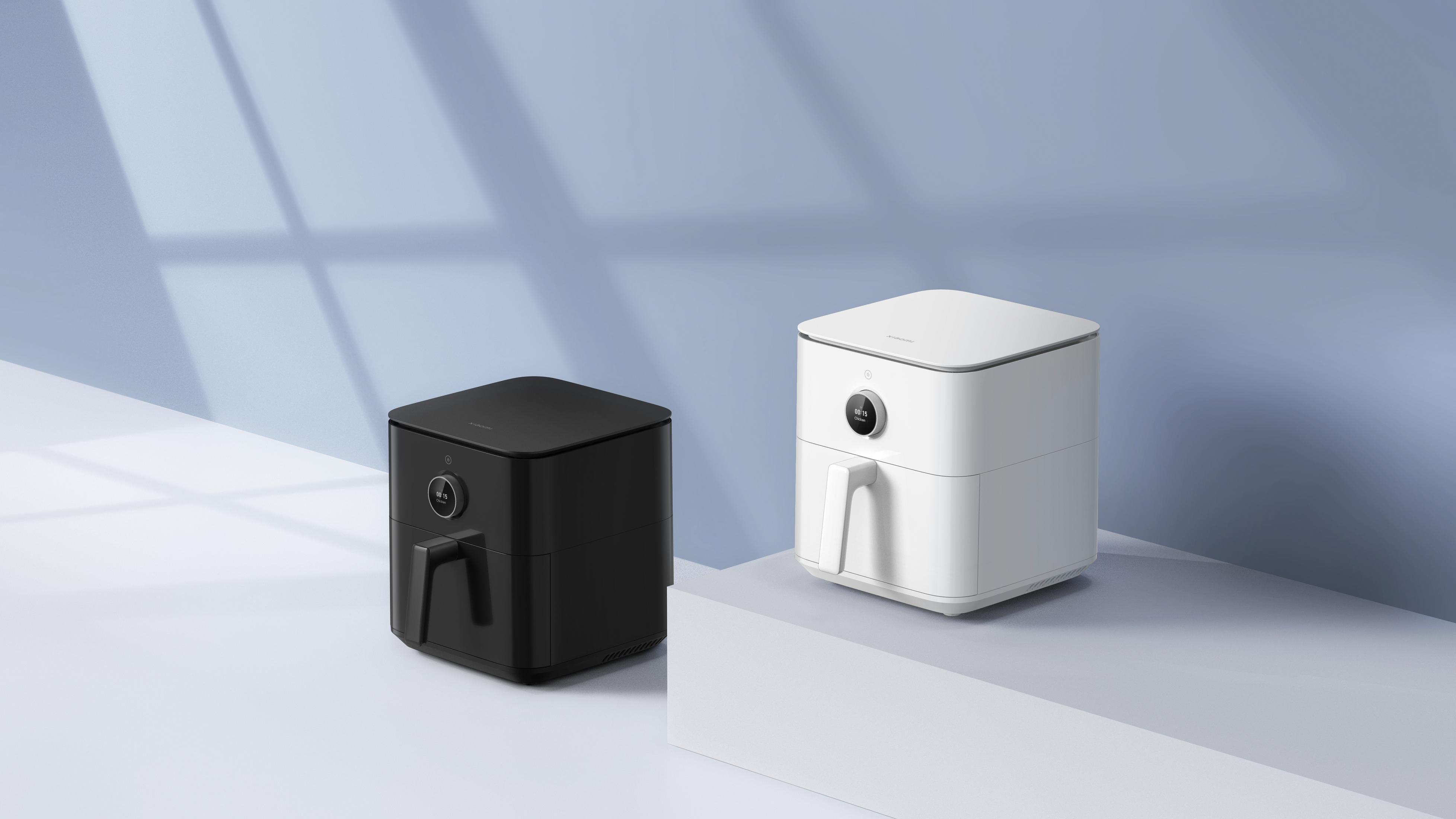 Czarny i biały air fryer stoją obok siebie na platformie.