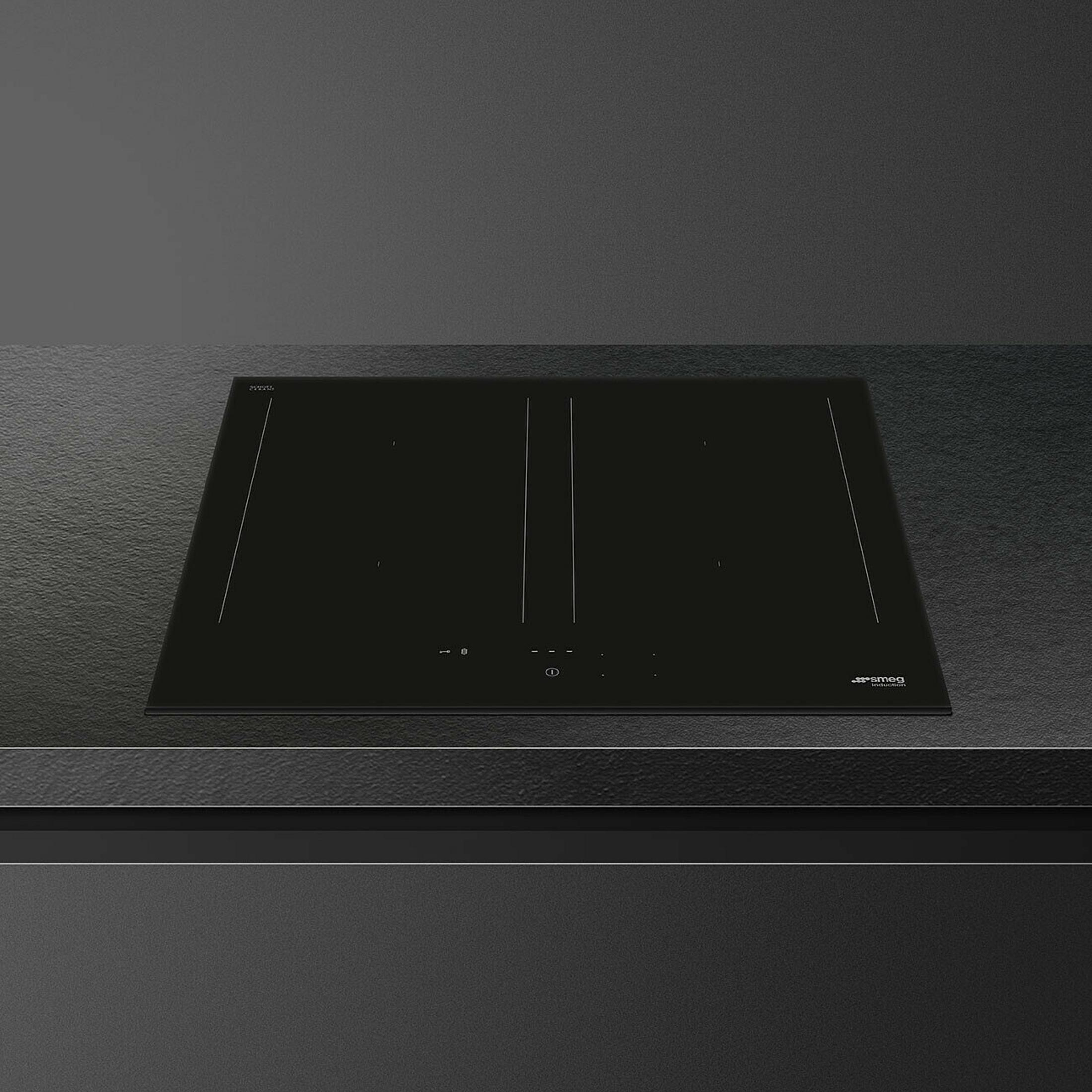 Un piano cottura a induzione nero con controlli touch su un piano di lavoro scuro.