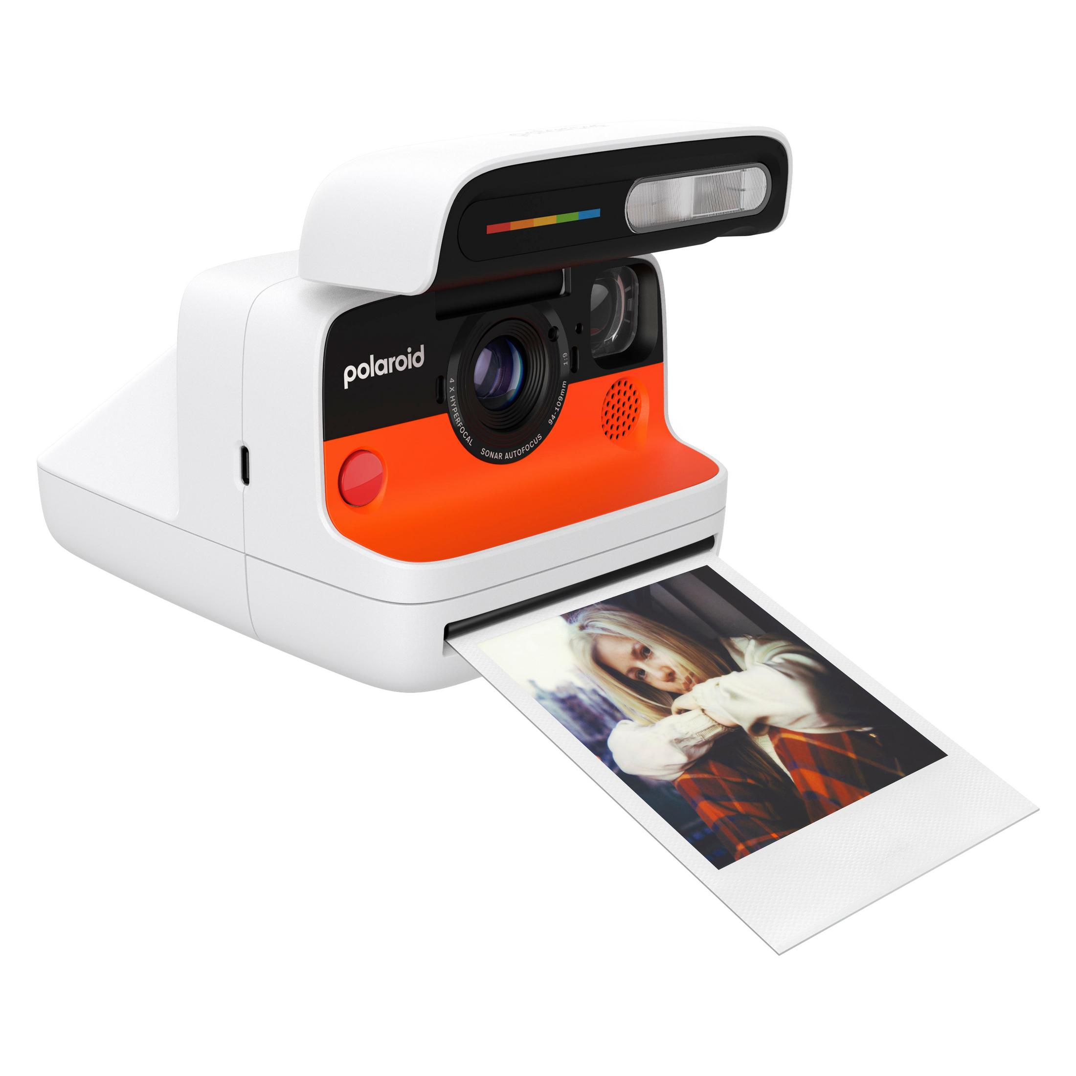 Eine weiße Polaroid-Kamera mit orangefarbener Vorderseite und einem Foto.