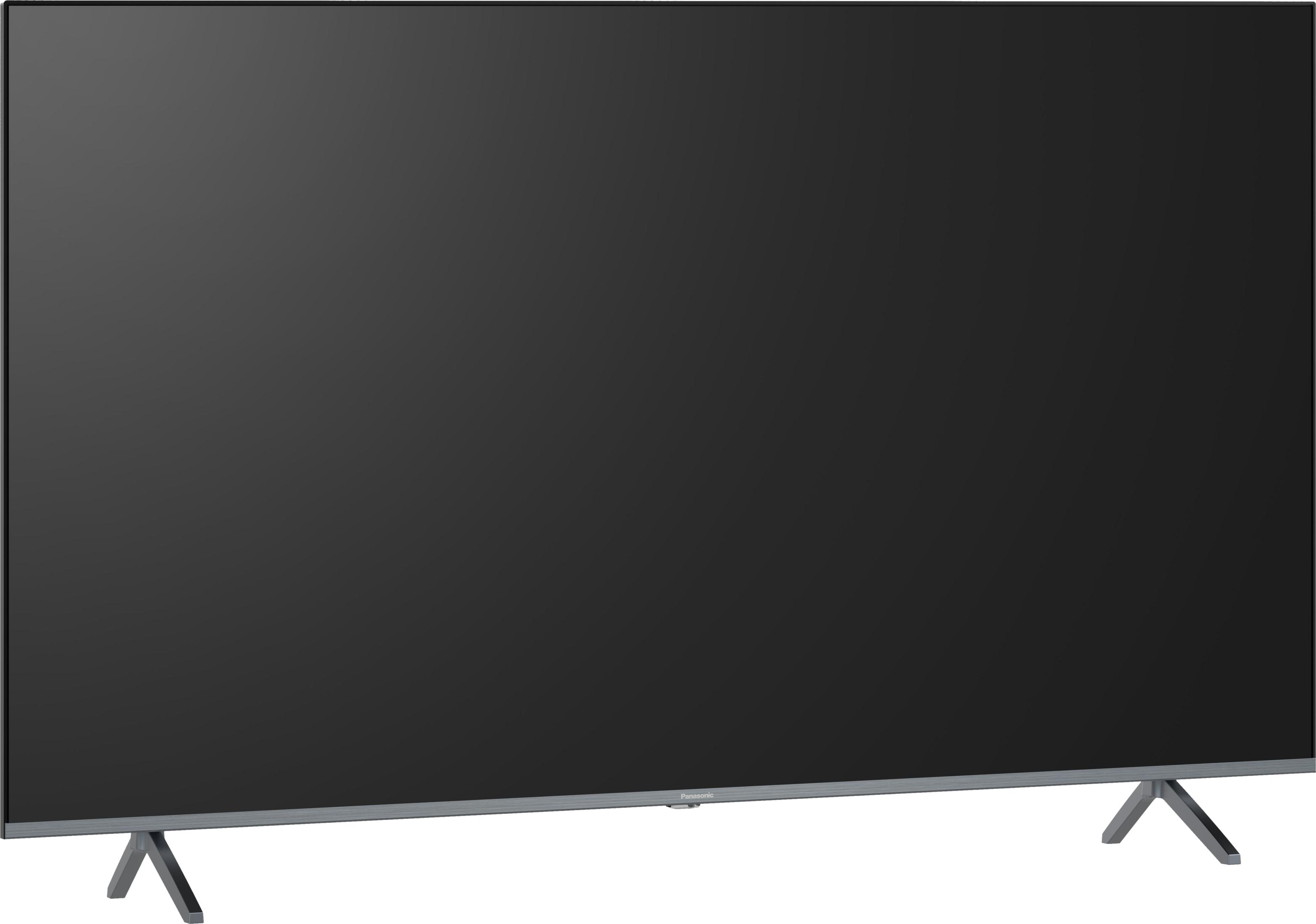 Una TV moderna a schermo piatto con schermo scuro e piedini argentati.