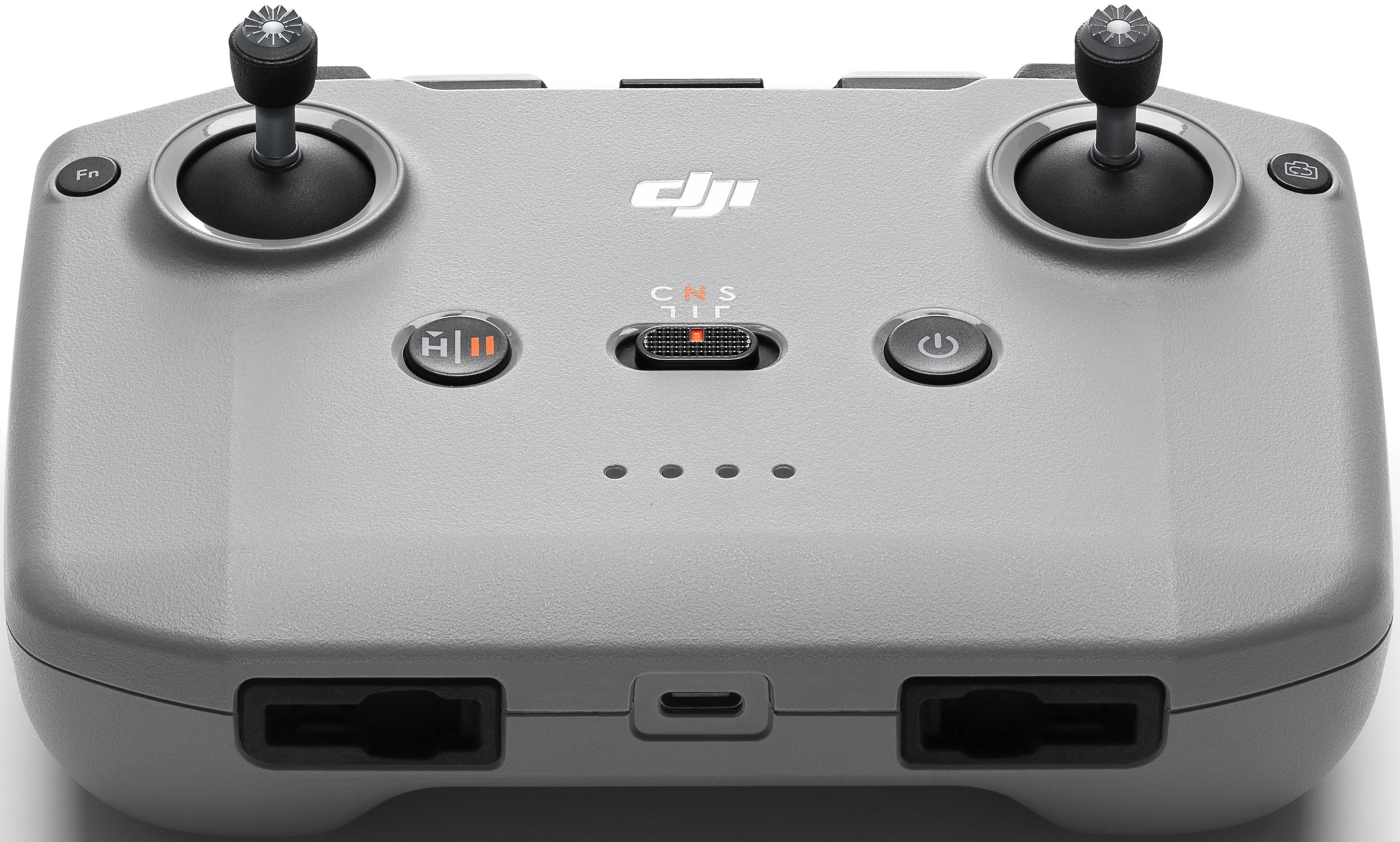 Szary kontroler DJI z dwoma joystickami, przyciskami i portem ładowania.