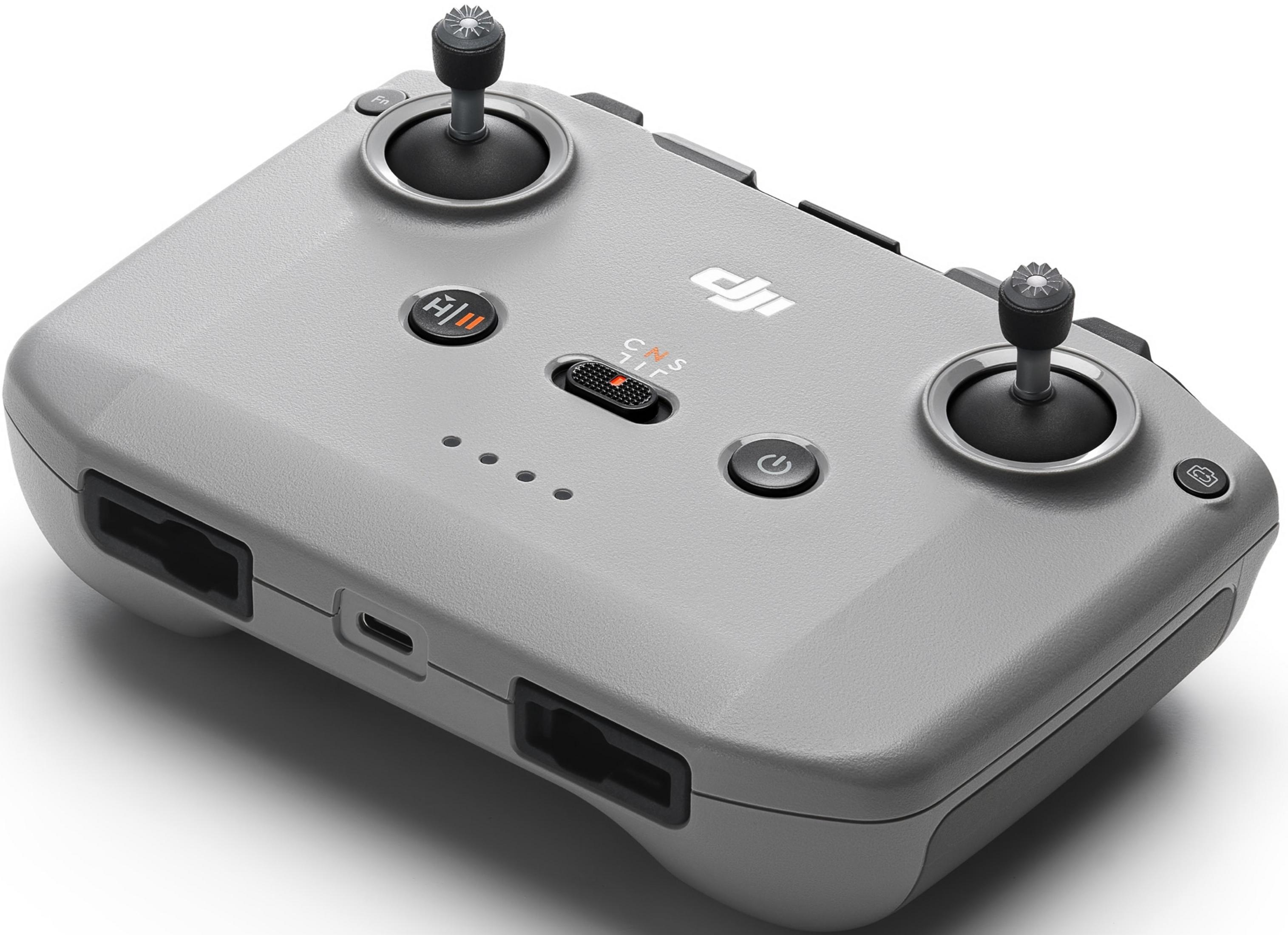 Szary kontroler drona z dwoma joystickami, przyciskami i portem ładowania.