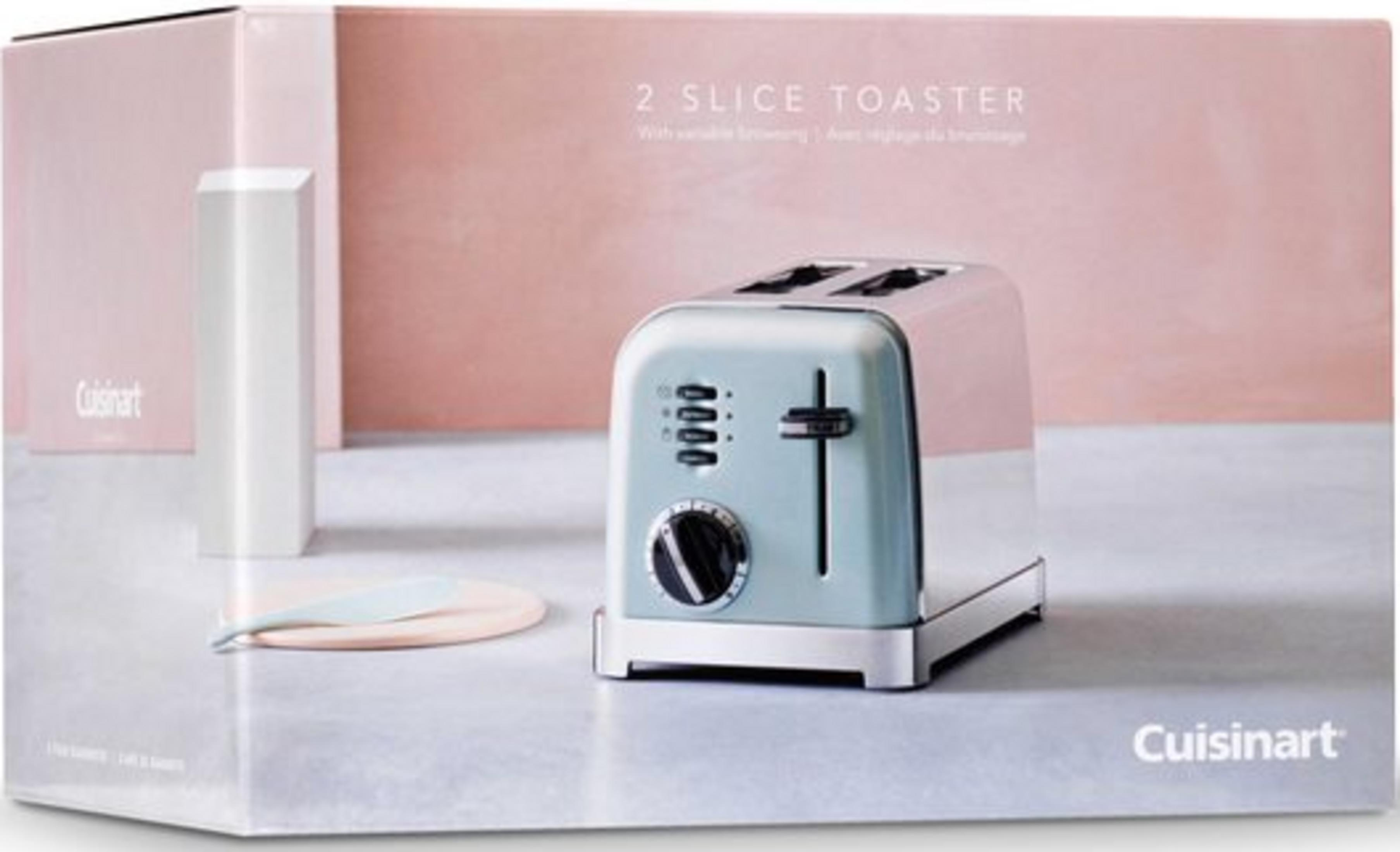Jasnoniebieski toster Cuisinart stoi na stole z różowym pudełkiem w tle.
