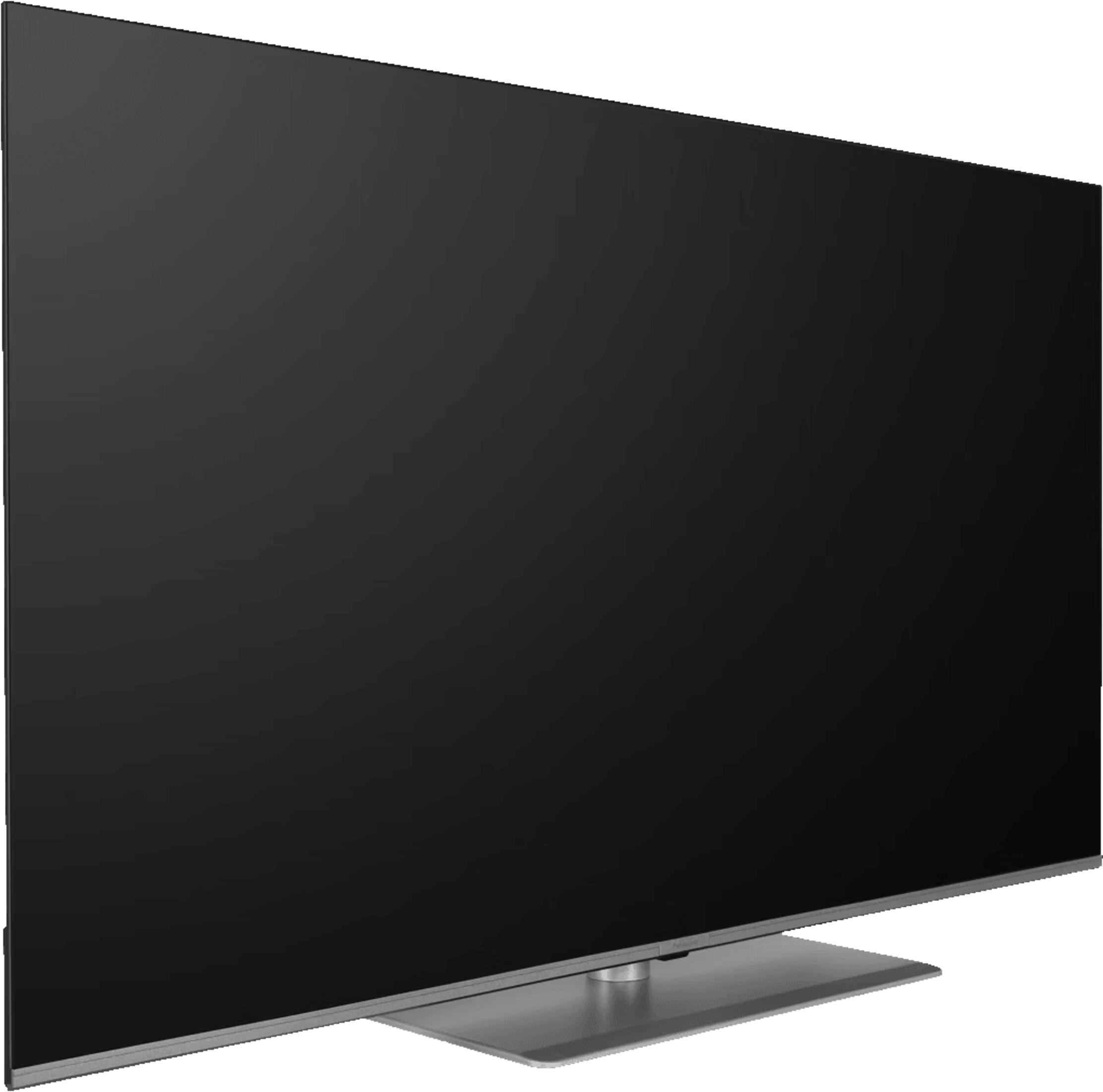 Un televisor grande de pantalla plana y negro sobre un soporte plateado.