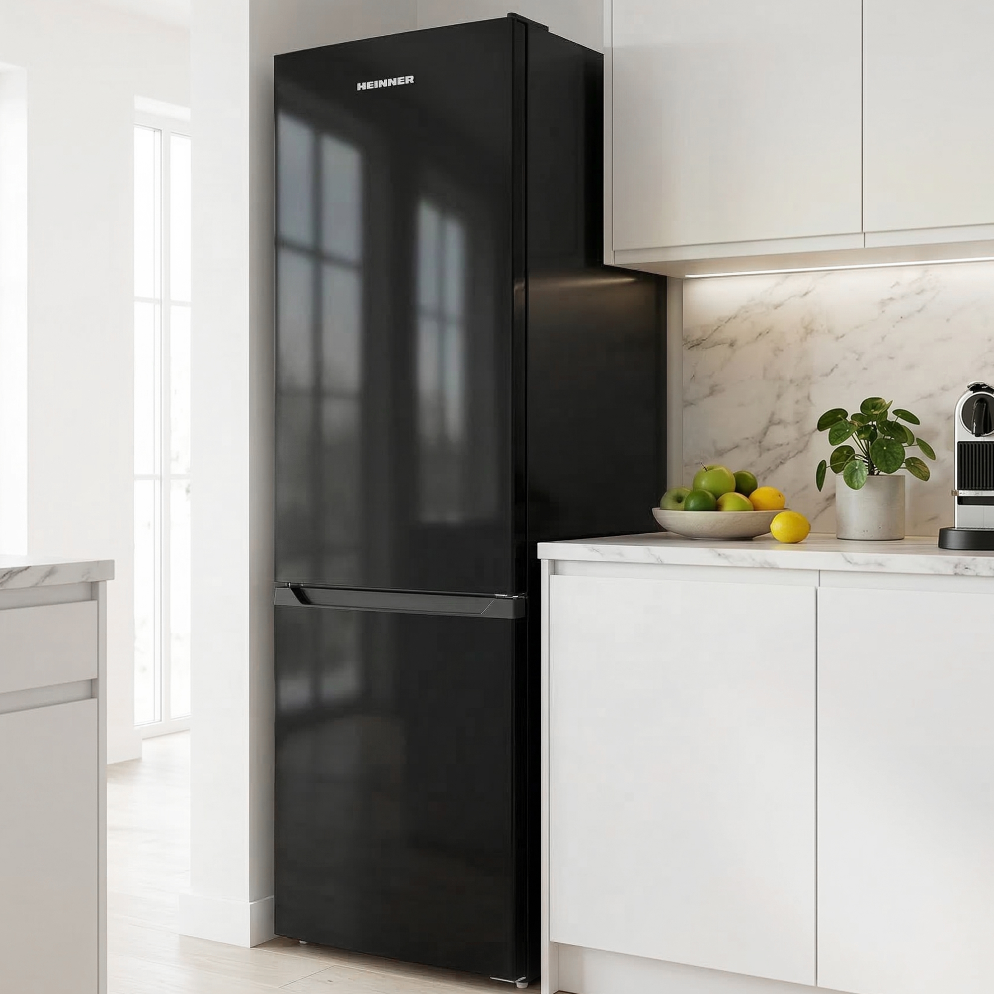 Een zwarte Heinner koelkast staat in een moderne keuken met witte kasten en marmeren aanrechtbladen.