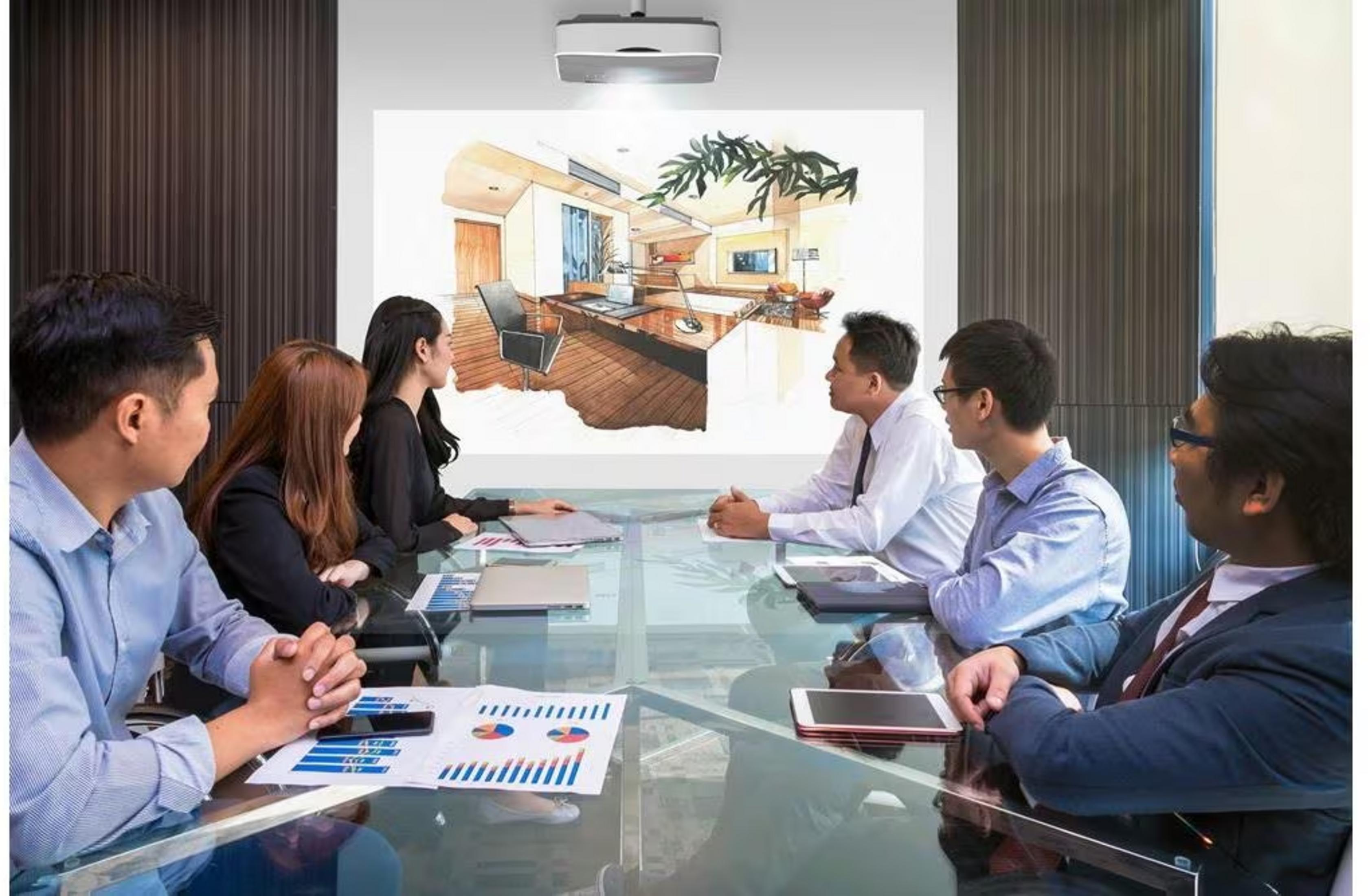 Ludzie w sali konferencyjnej patrzą na projekcję nowoczesnego projektu wnętrza.