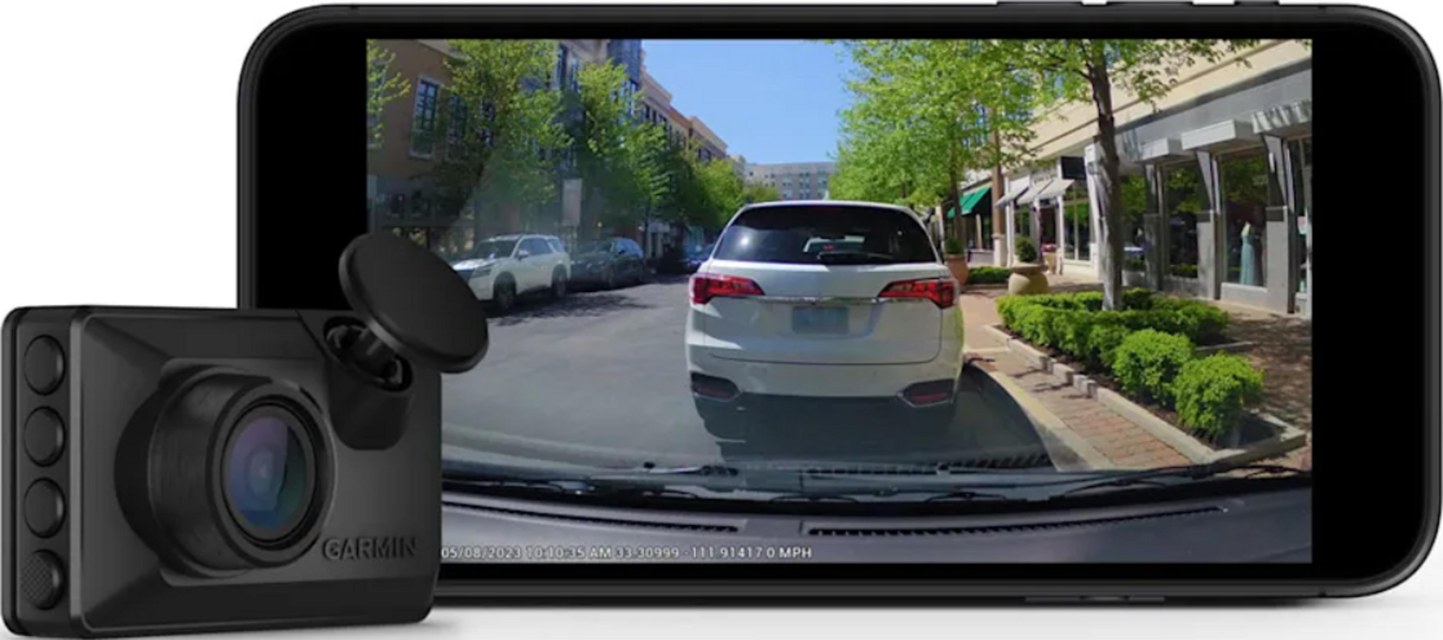 Garmin Dashcam vor einem Smartphone mit Straßenansicht, Autos und Gebäuden.