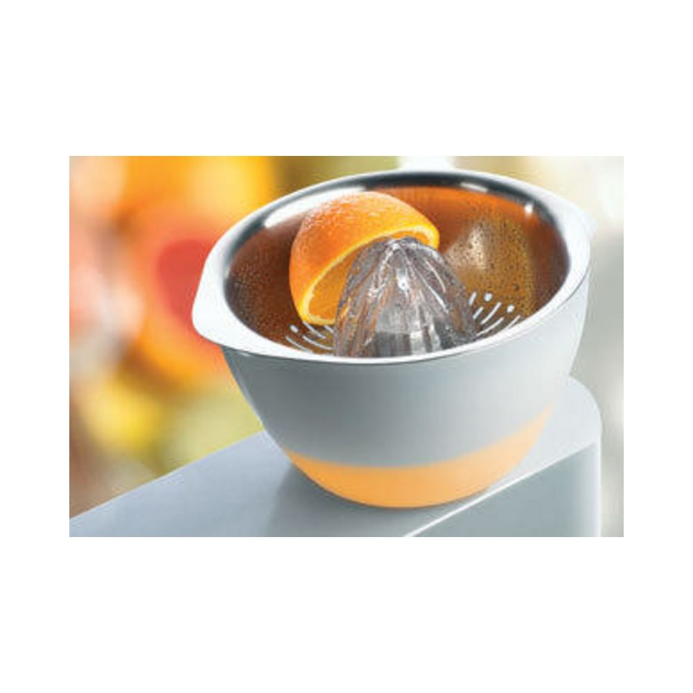 Połówka pomarańczy jest dociskana do wyciskarki do cytrusów w misce.