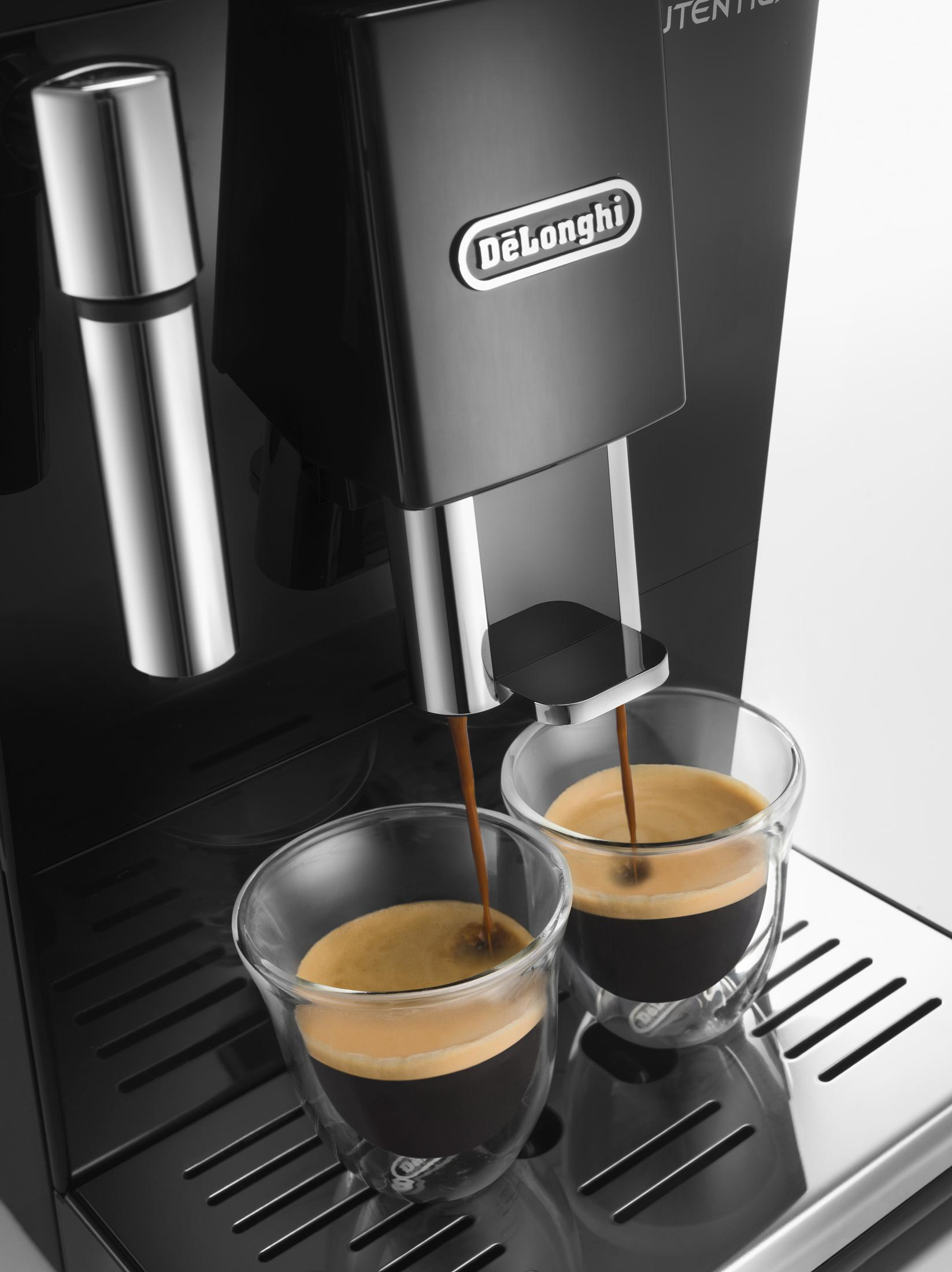 Een koffiezetapparaat zet twee espresso's in glazen kopjes.