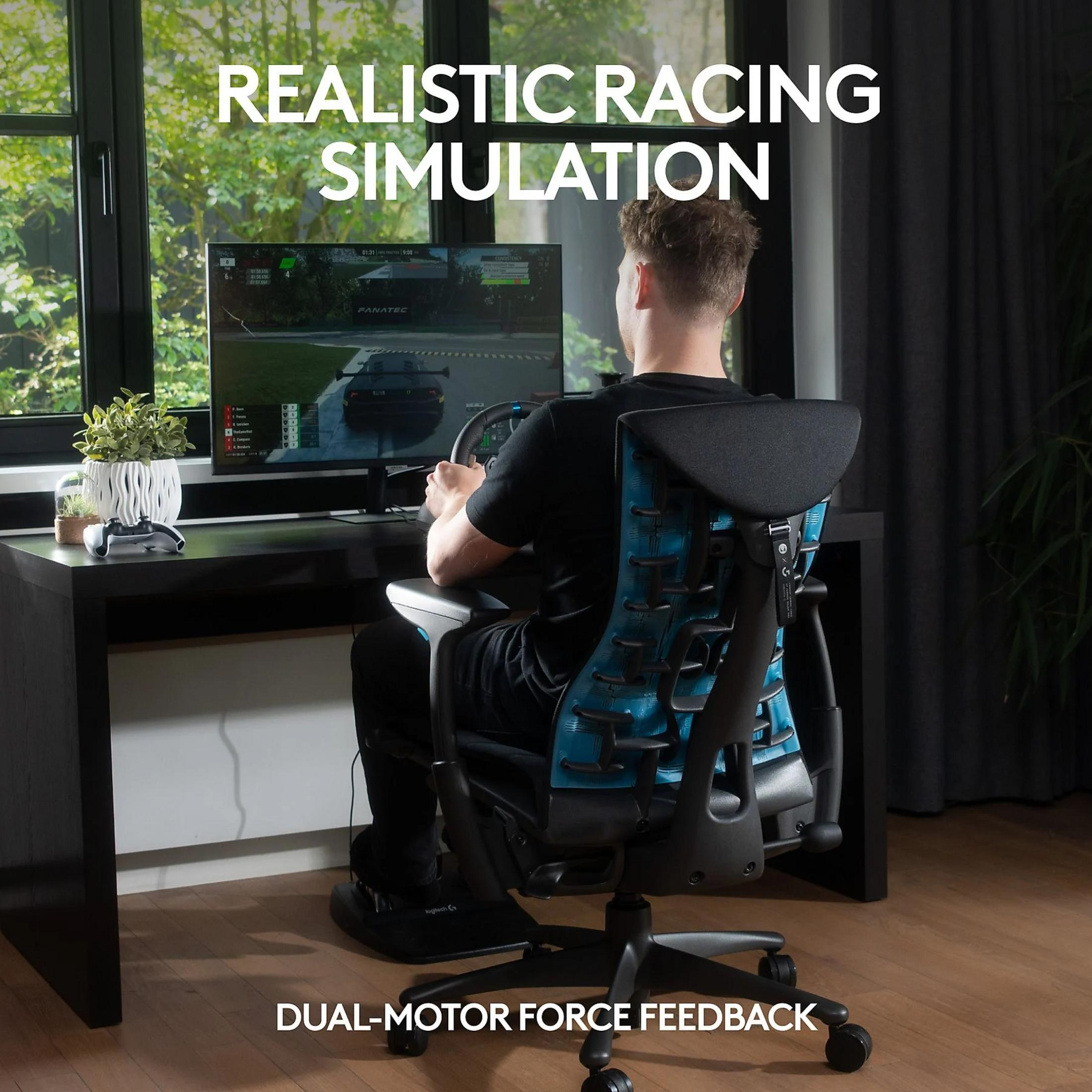 Man speelt race-simulatie met stuur en pedalen aan een bureau.