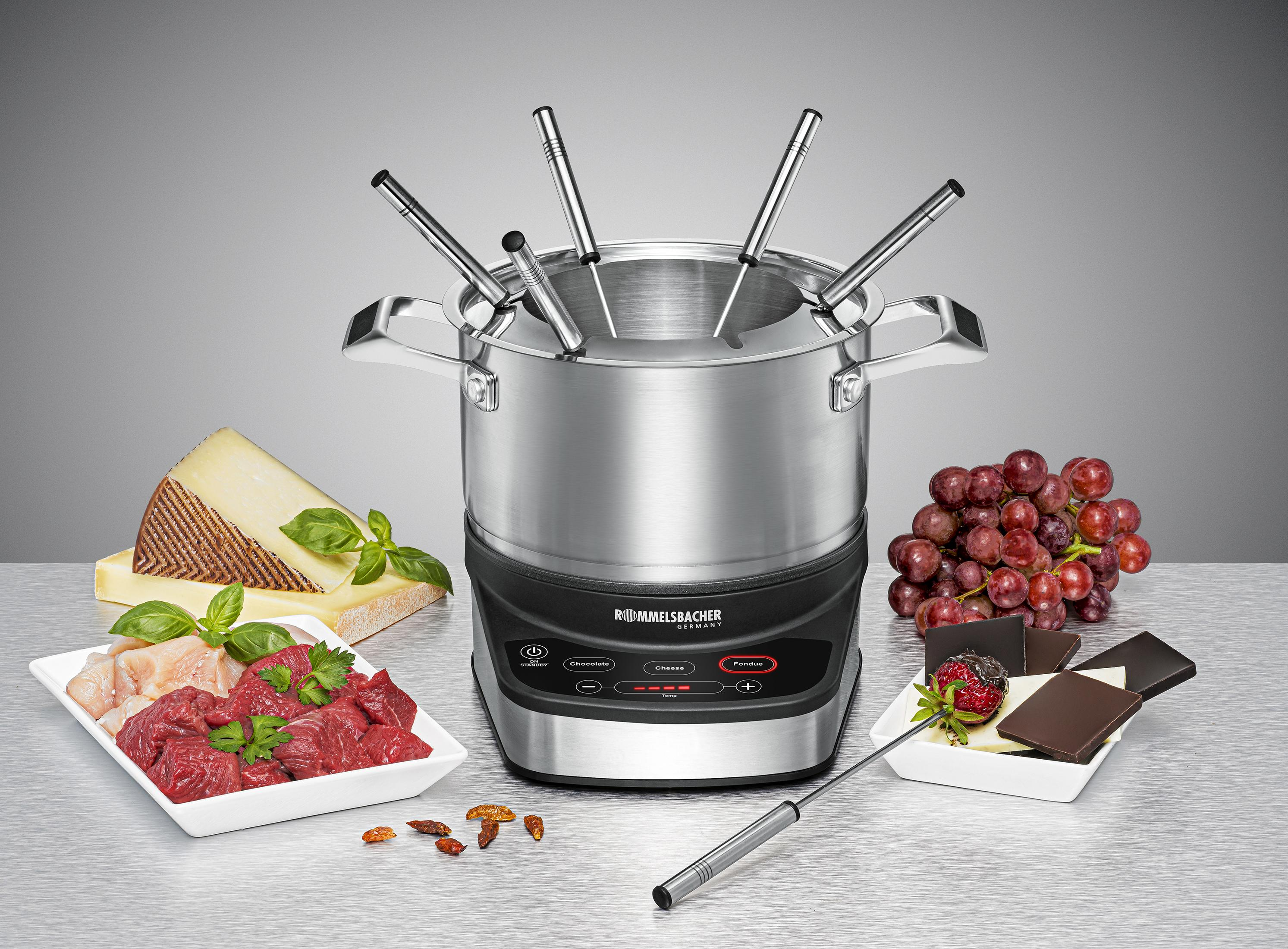 Ein Fondue-Set mit Fleisch, Käse, Schokolade, Trauben und Chilis.