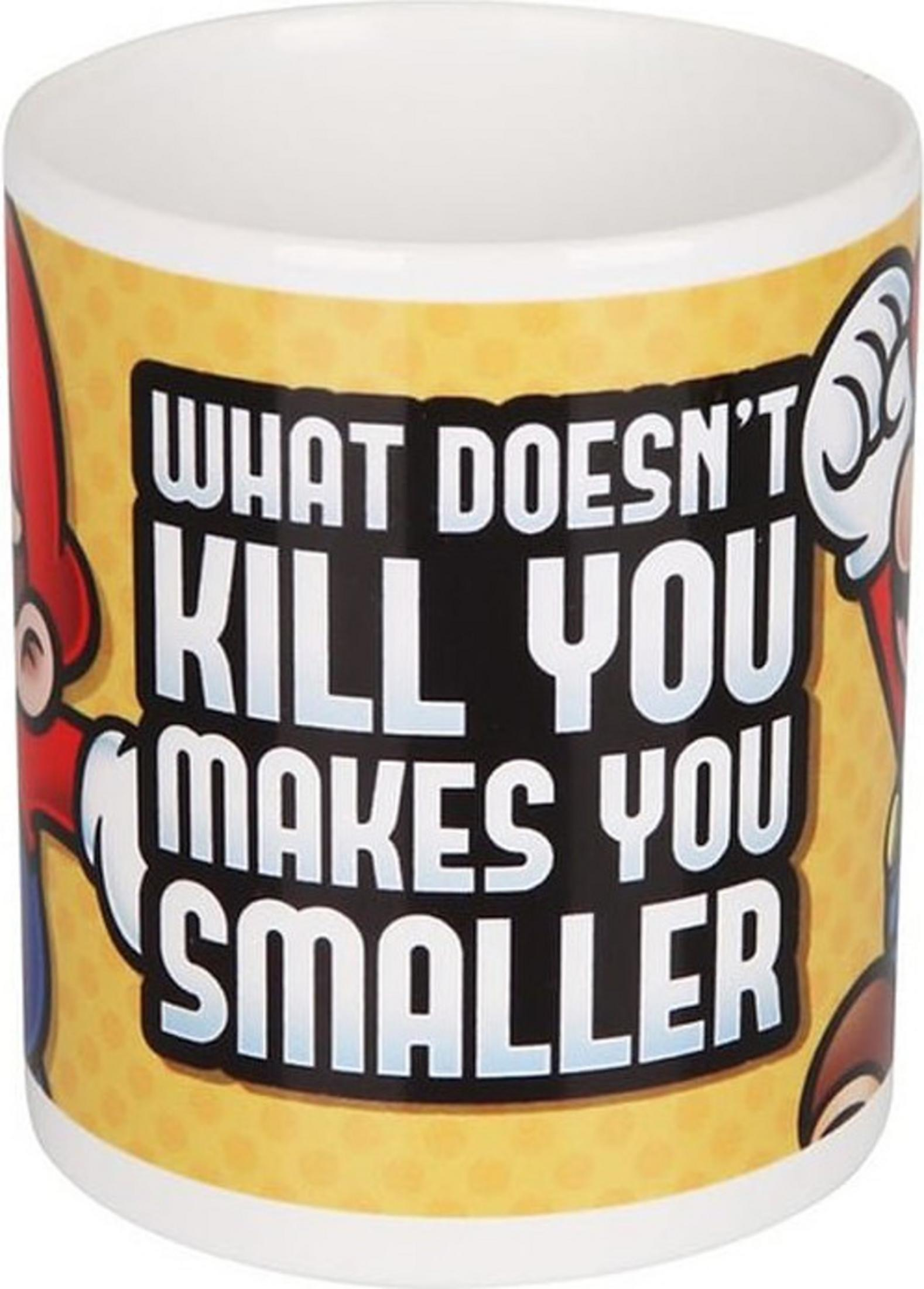Una taza blanca con fondo amarillo y personajes de Mario. Texto: Lo que no te mata te hace más pequeño.
