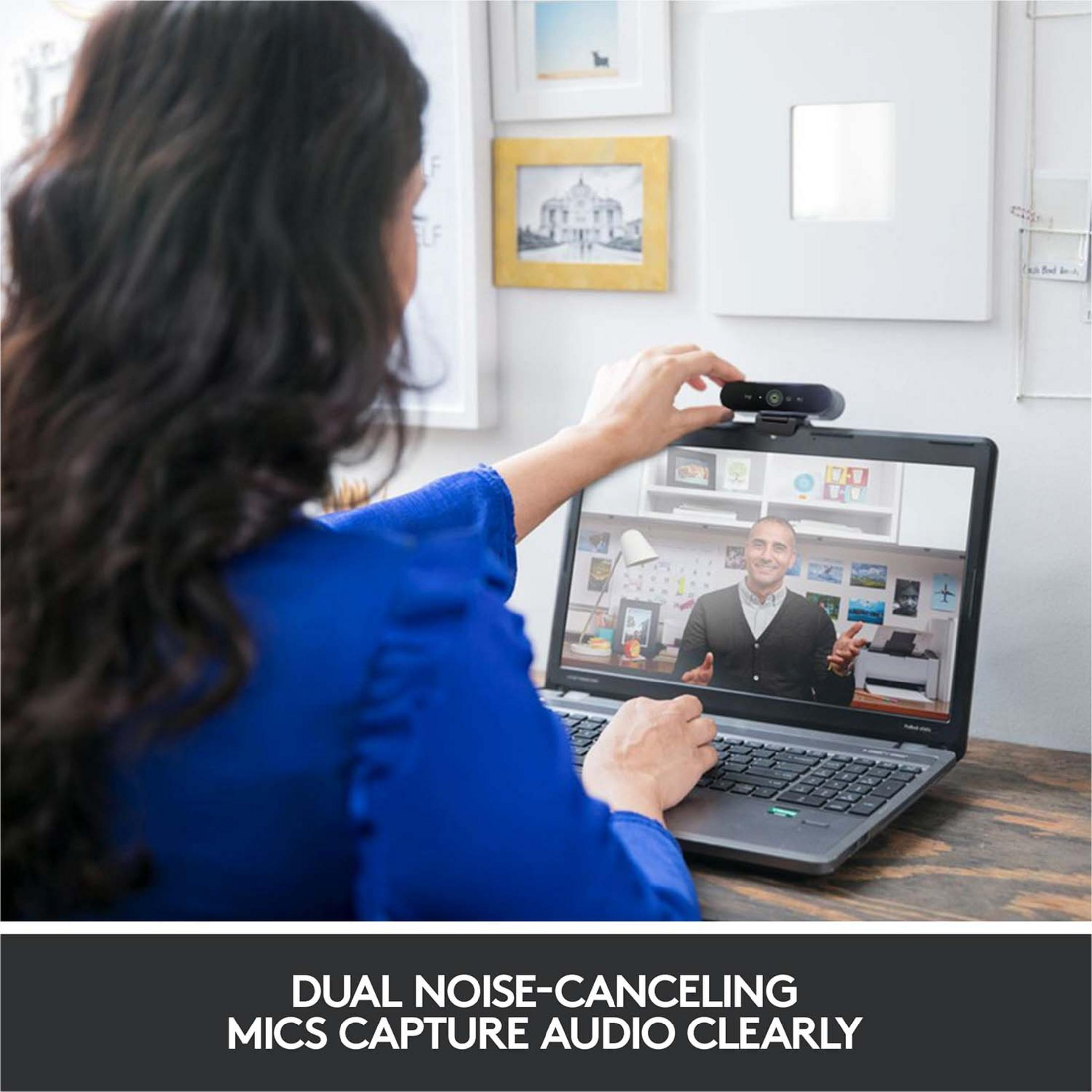 Kobieta z ciemnymi włosami umieszcza kamerę internetową na laptopie.