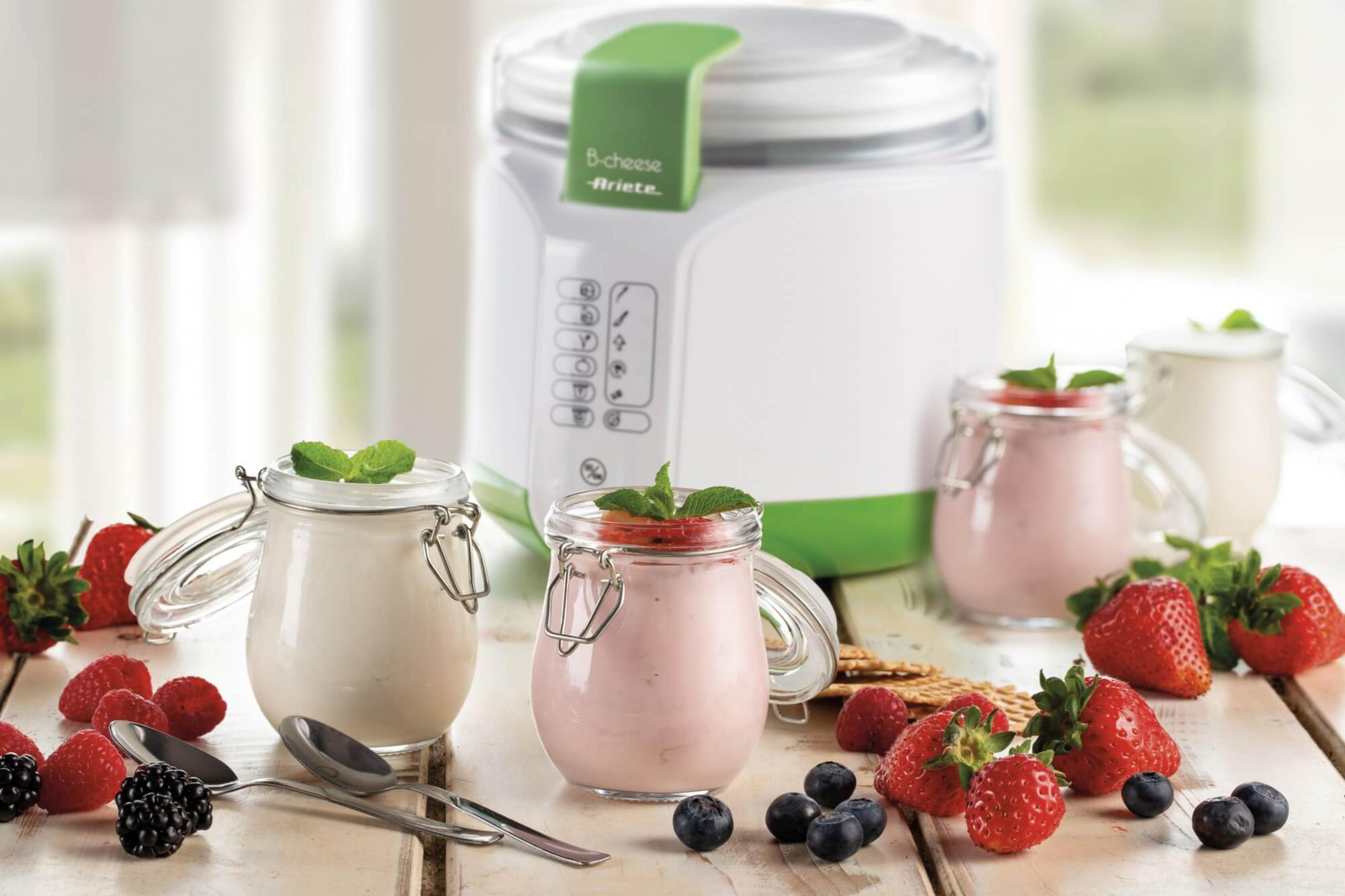 Una yogurtiera con barattoli, bacche e cracker.