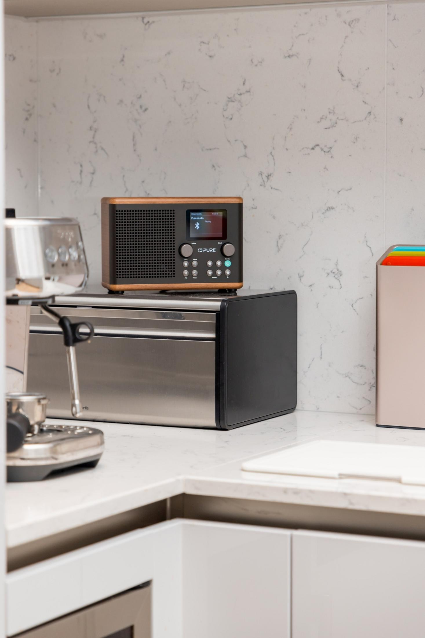 Nowoczesny blat kuchenny z ekspresem do kawy, tosterem i radiem.