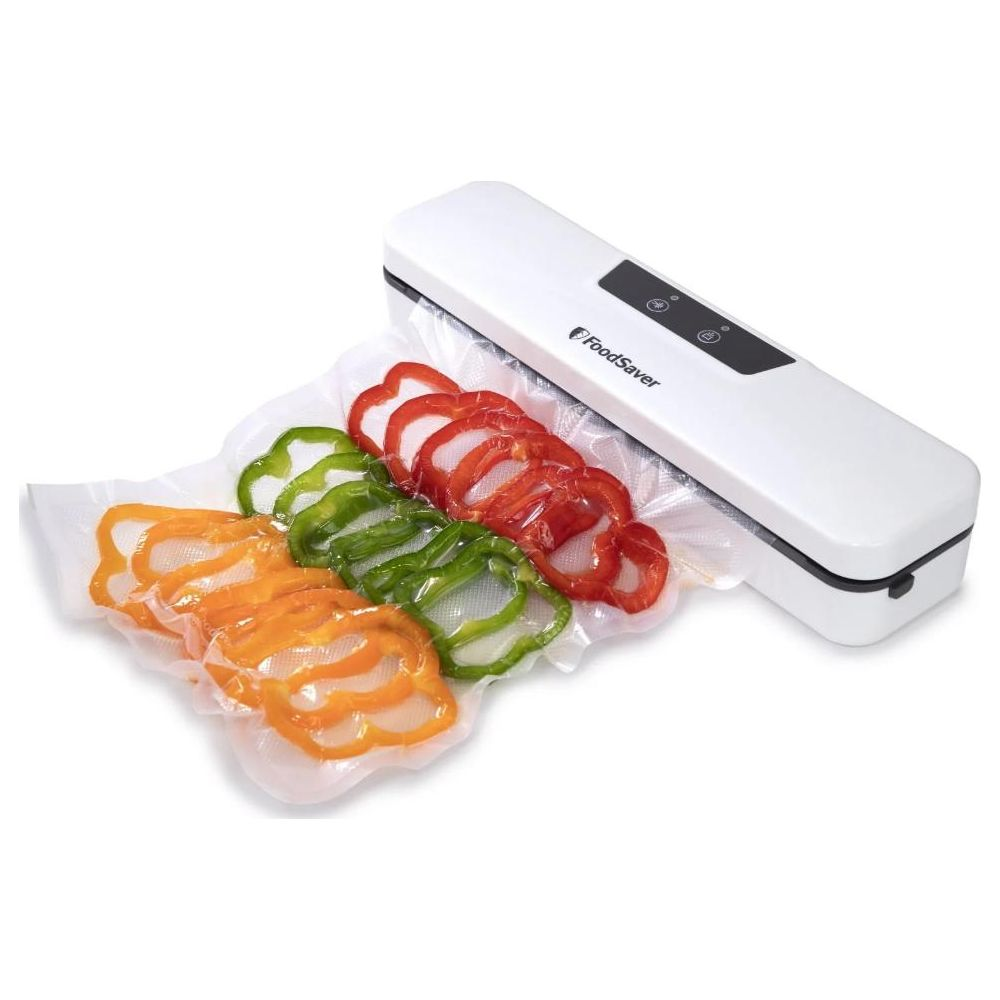 Biała zgrzewarka próżniowa zamyka w plastiku plasterki papryki w kolorze pomarańczowym, zielonym i czerwonym.