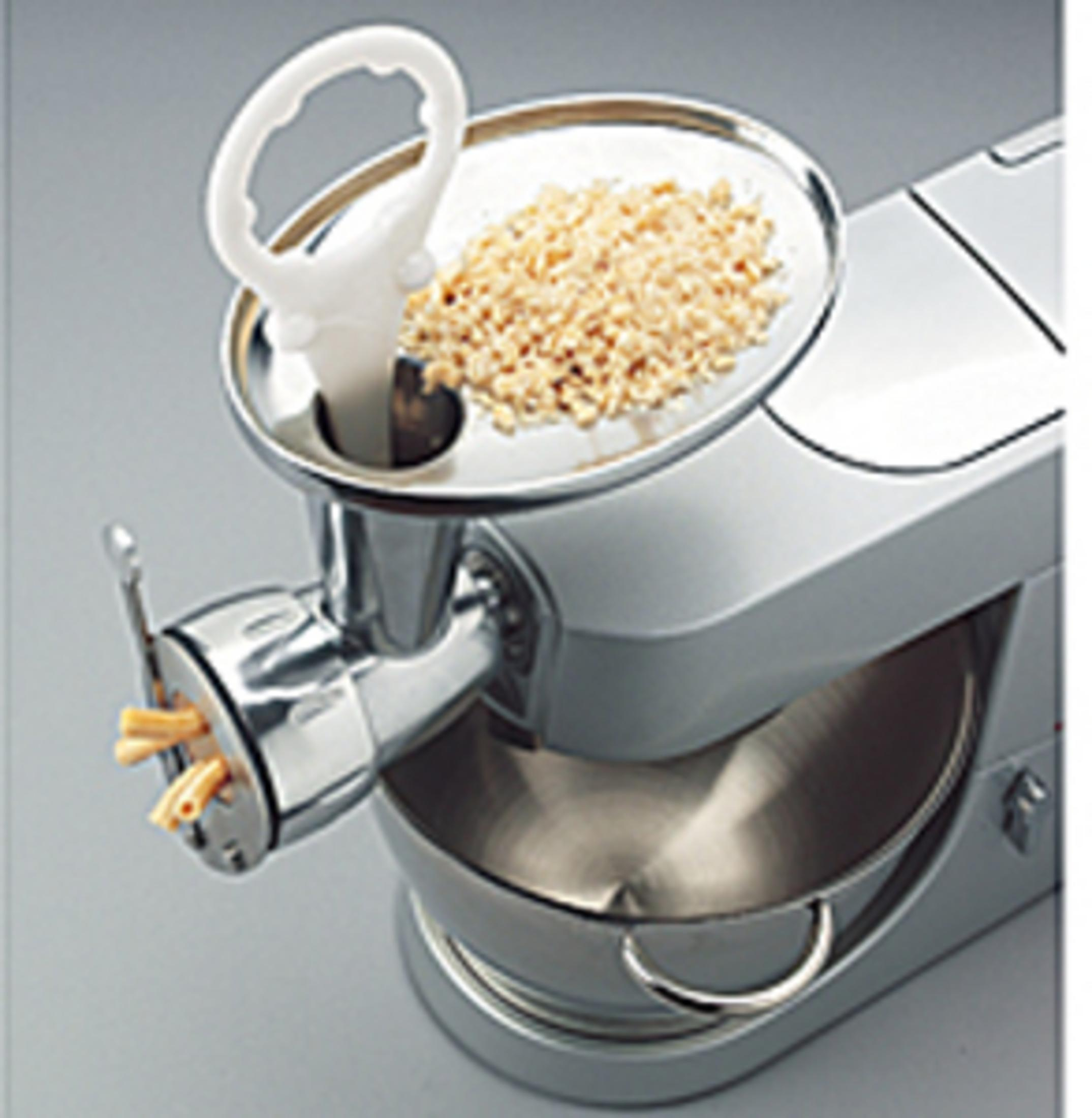 Eine Küchenmaschine mit Nudelaufsatz, die gerade Nudeln produziert.