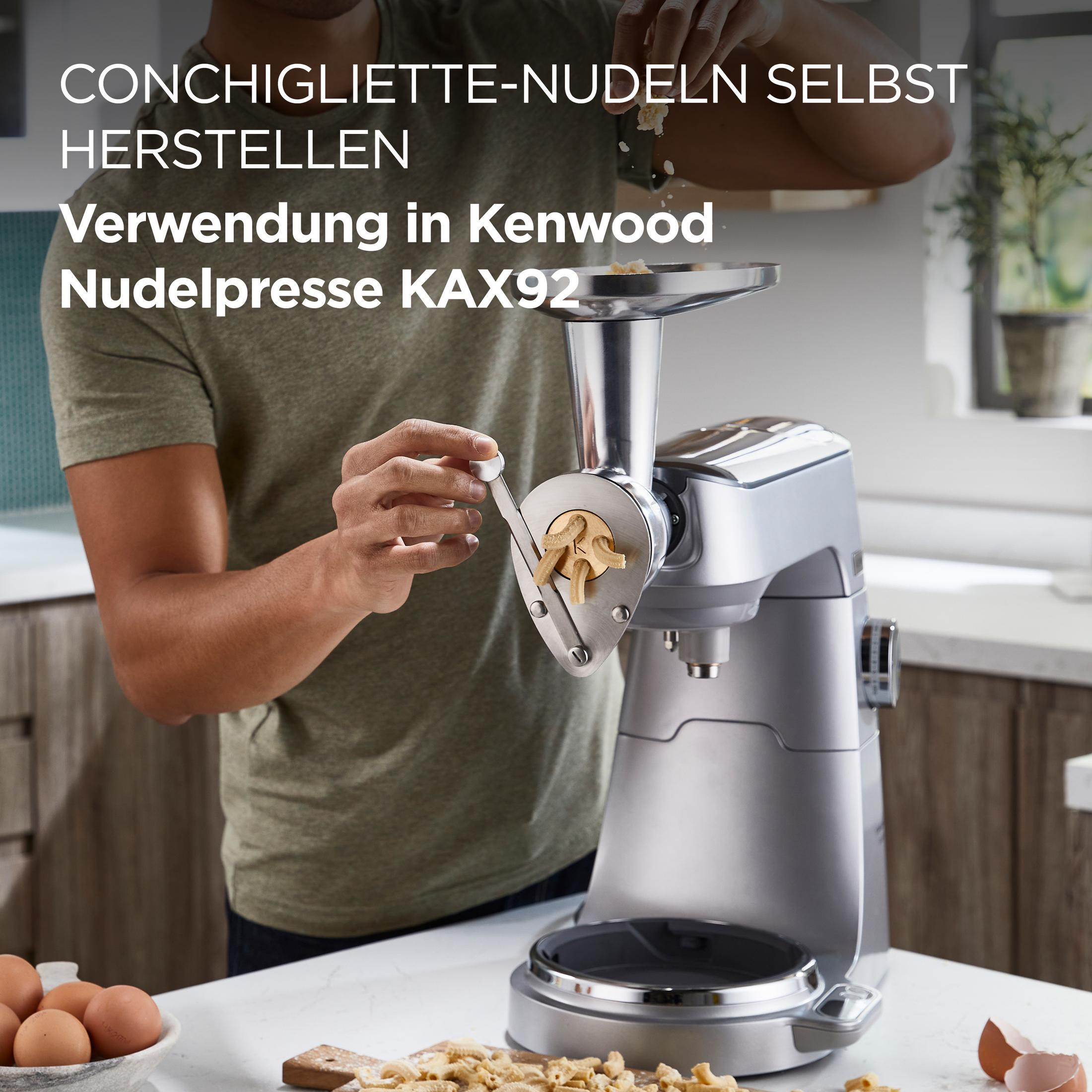 Ein Mann benutzt eine Nudelmaschine, um Conchiglioni-Nudeln herzustellen.